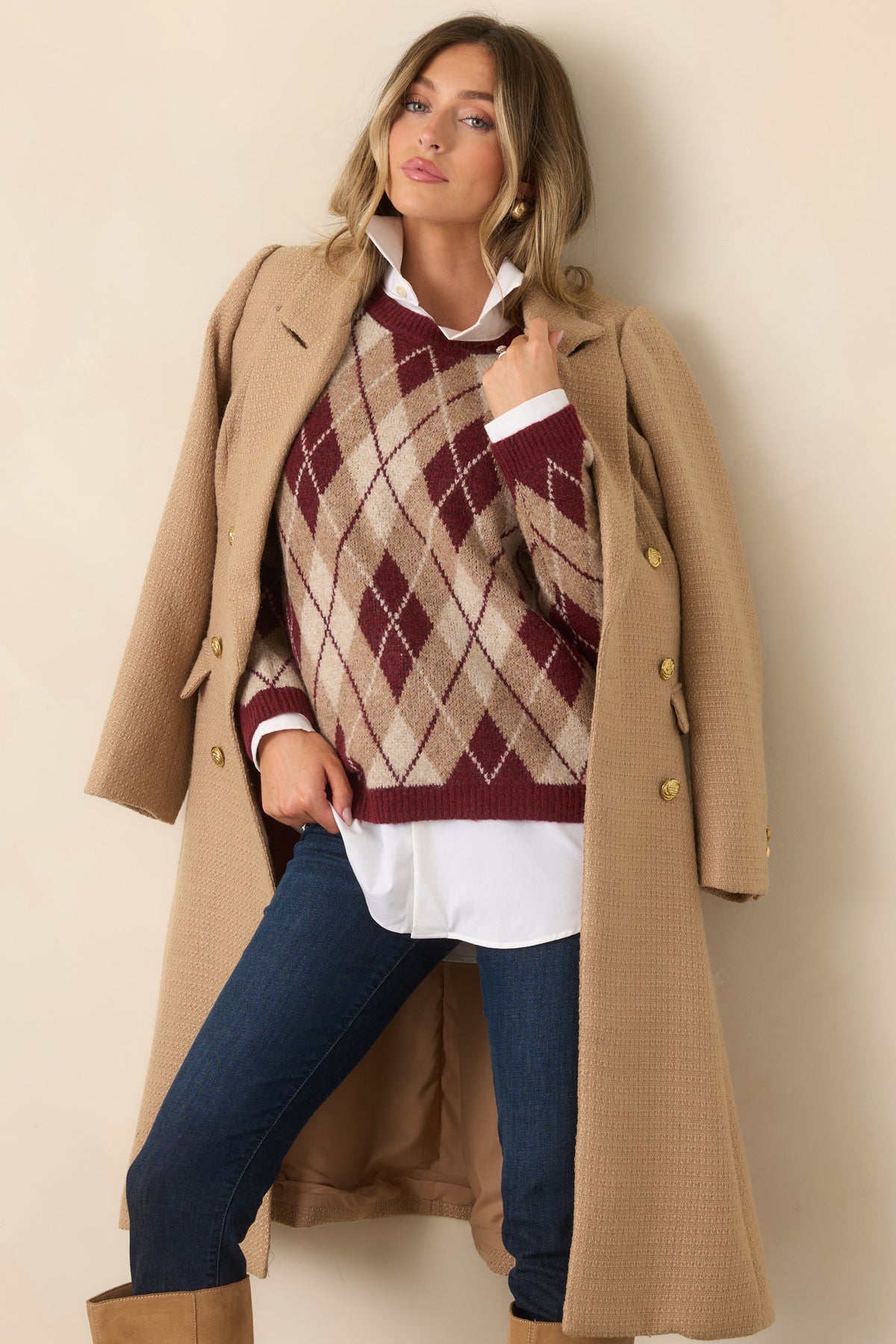 The relaxed silhouette showcases an allover burgundy and neutral argyle pattern with ribbed cuffs and hem.