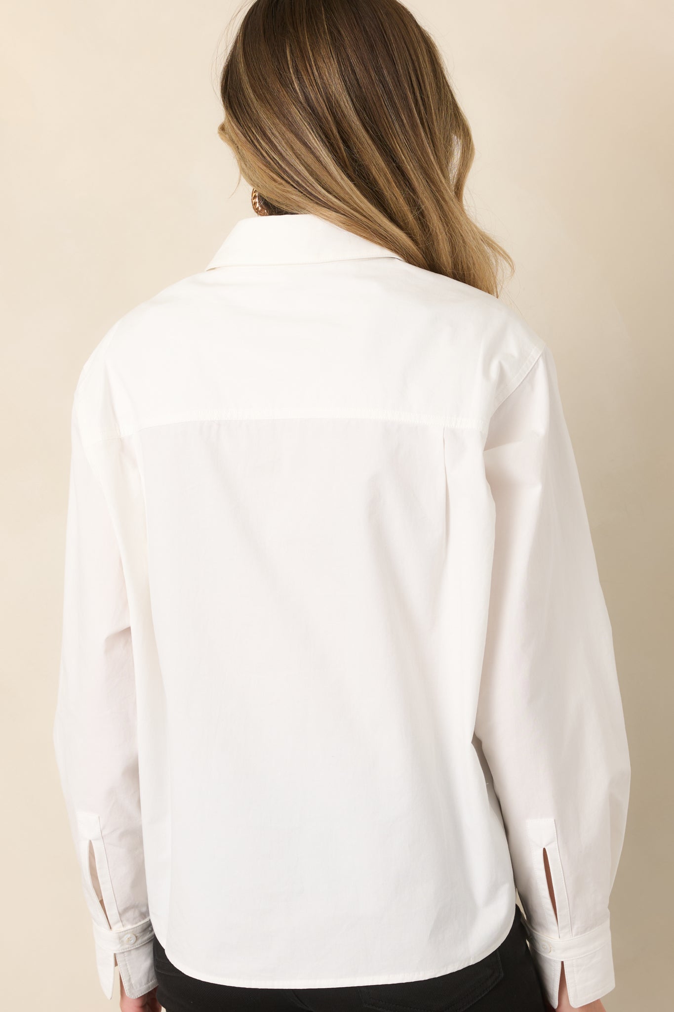 Rear view of the relaxed button-front top showing the back yoke, long sleeves, and easy oversized silhouette.