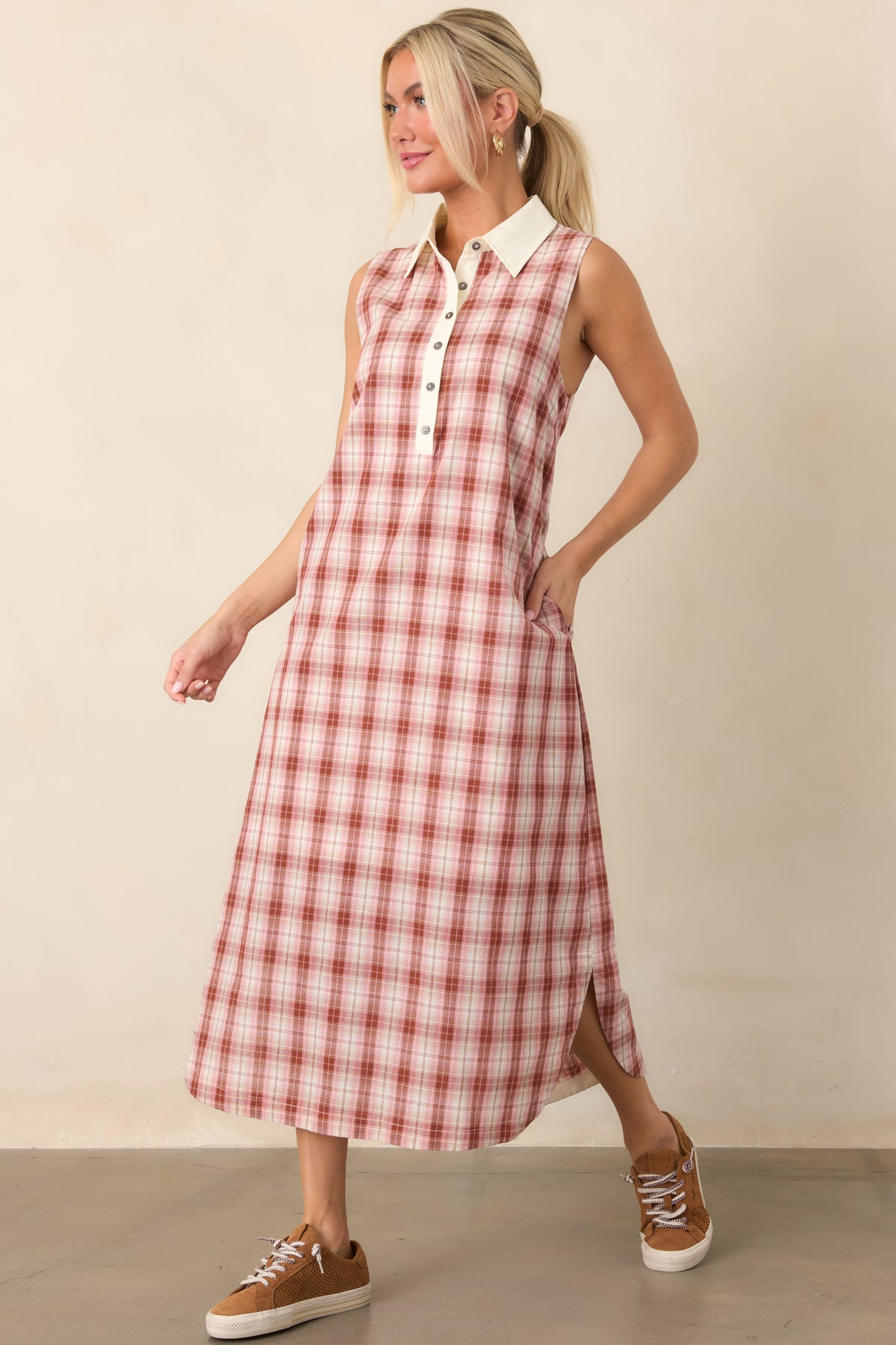Relaxed cotton dress highlighting the sleeveless shape, crisp collar, contrasting ivory trim, partial button placket, and practical side pockets.