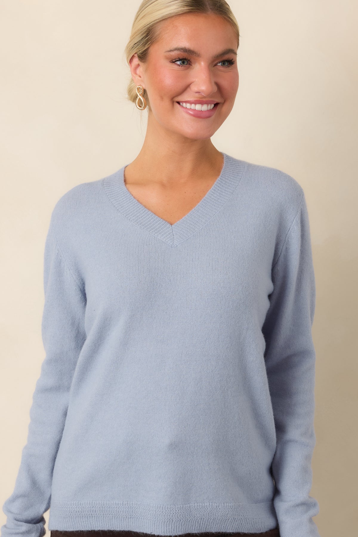 Relaxed dusty blue top featuring a soft wool-blend knit and ribbed hem.