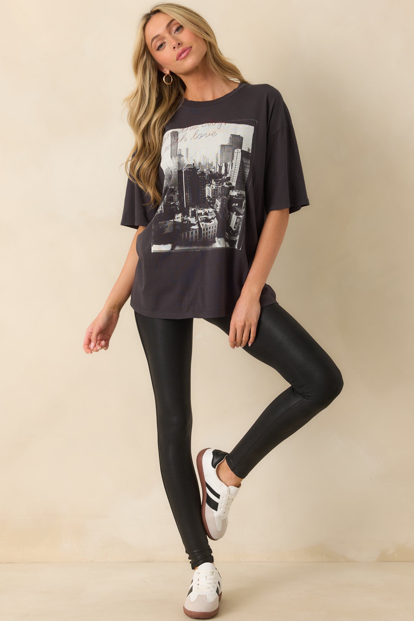 Relaxed fit black tee styled with a bold black and white city print and cursive red lettering.