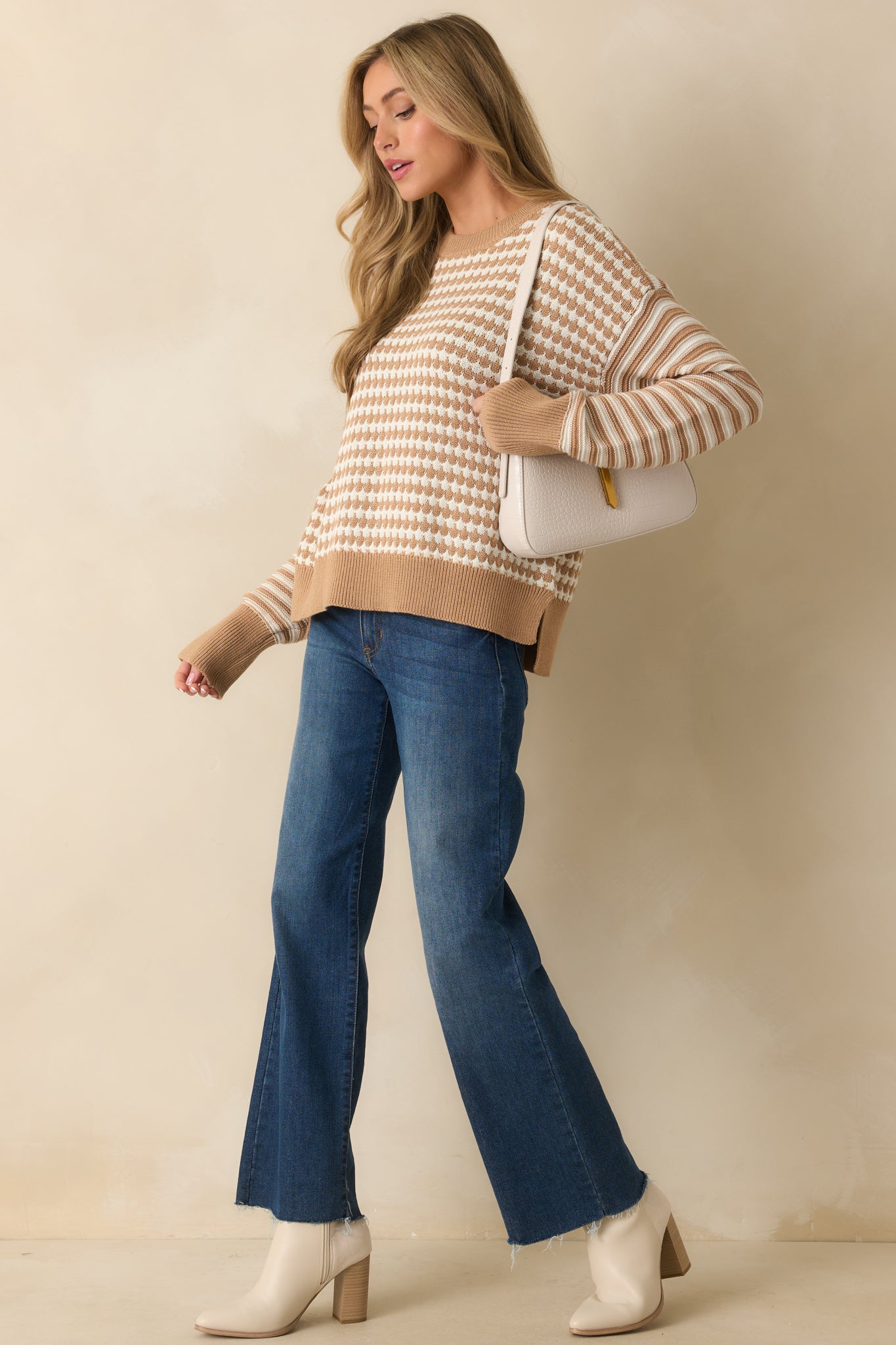 Relaxed-fit brown knit sweater with geometric body pattern and striped sleeves creating a modern casual look.