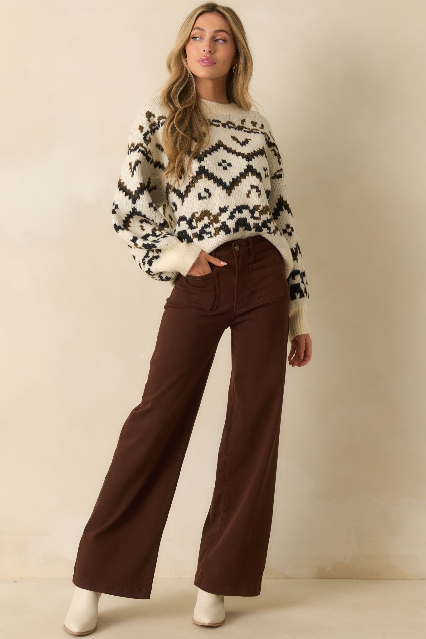 Relaxed-fit ivory sweater with dropped shoulders and patterned knit across the chest.