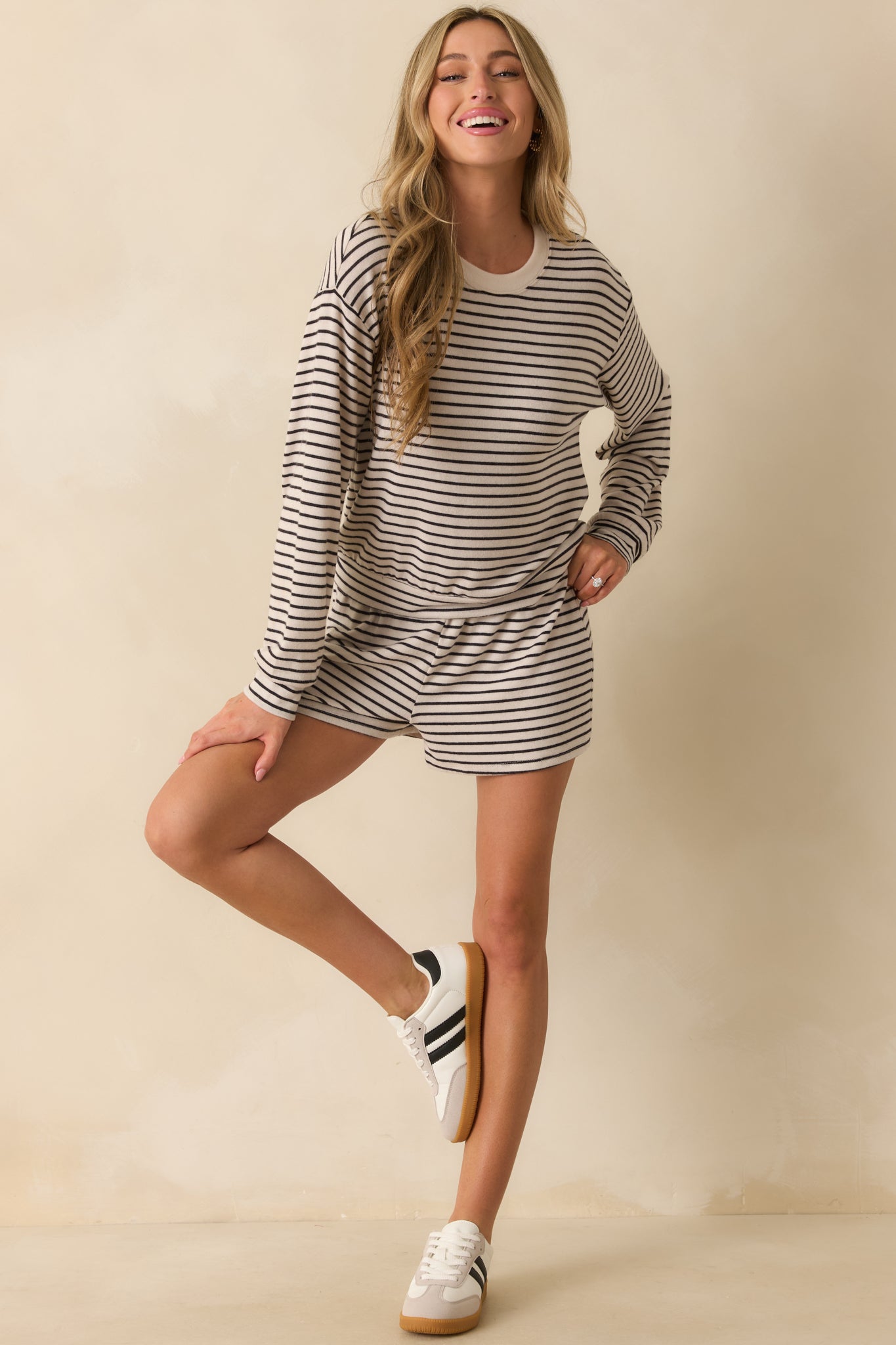 Relaxed-fit long sleeve tee with horizontal black stripes and soft ivory knit texture.