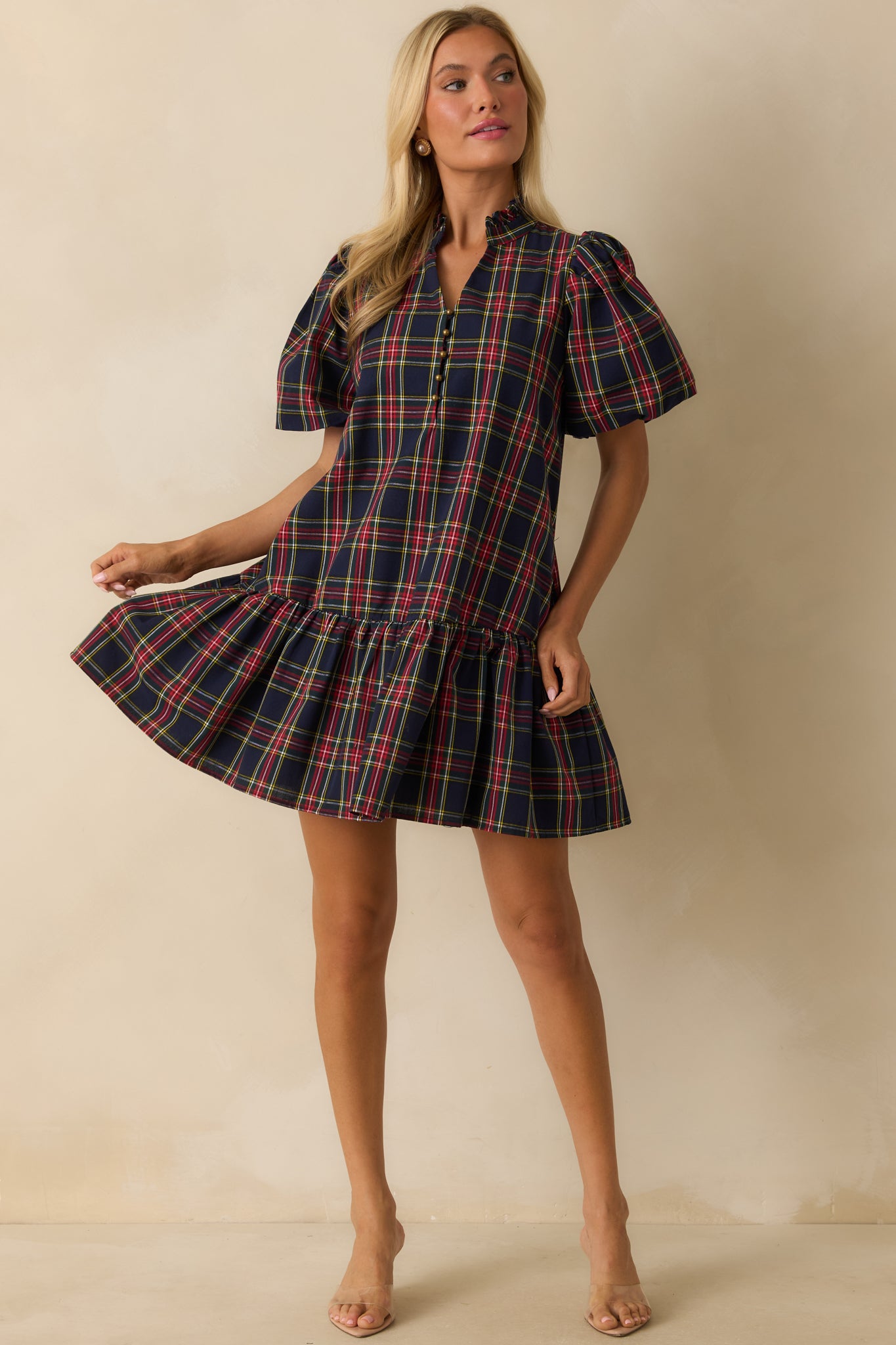 Relaxed-fit navy plaid mini dress with short puff sleeves, fully lined construction, and ruffled hem detail.