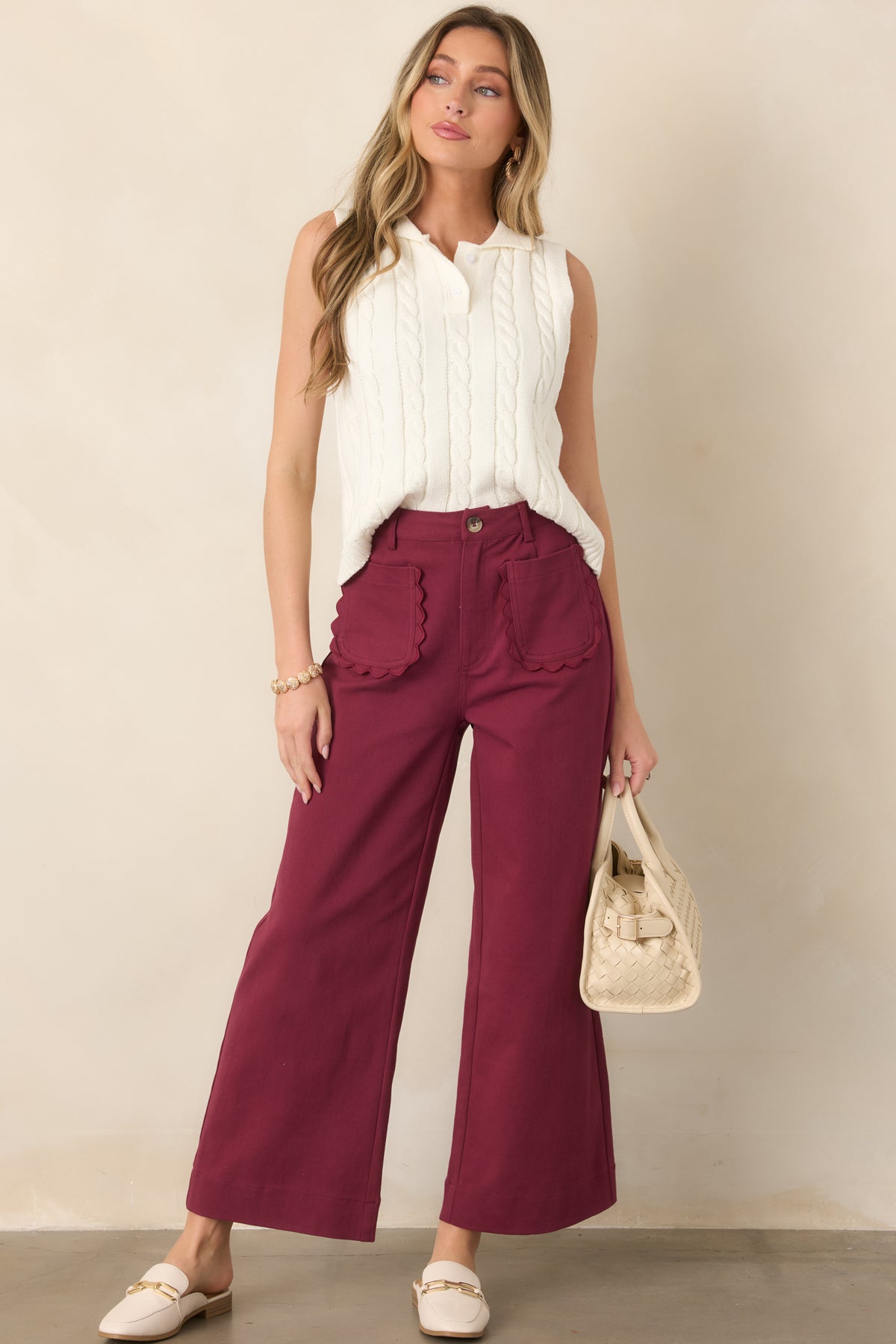 Relaxed ivory sweater vest with a textured cable-knit pattern, button-front closure, polo-style collar, and ribbed hem and arm openings.