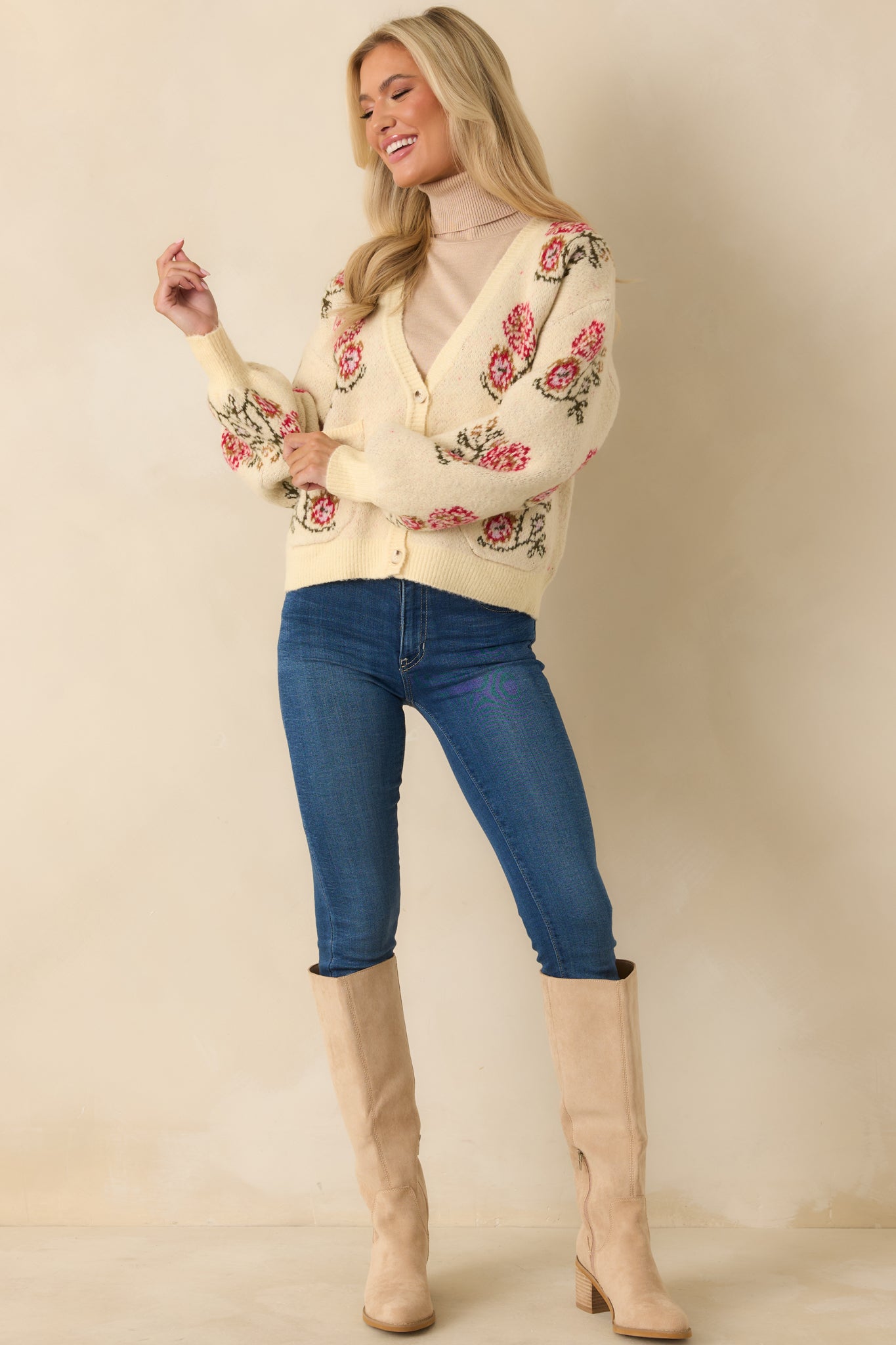 Relaxed ivory cardigan with long sleeves, button-front closure, and vintage-inspired floral pocket details.