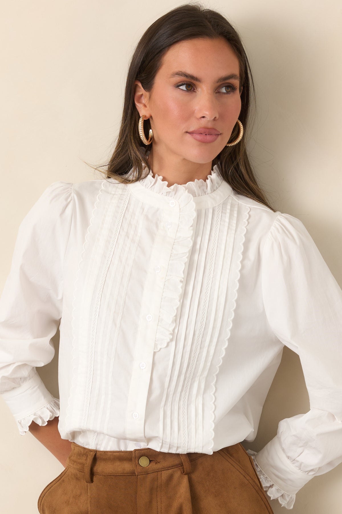 Relaxed blouse featuring delicate front pintucks and a ruffled neckline.