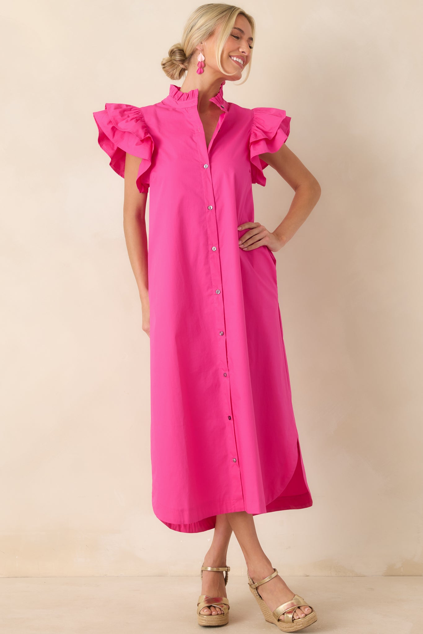 Relaxed midi dress featuring flutter sleeve detailing, side pockets, and a curved hem for a modern silhouette.