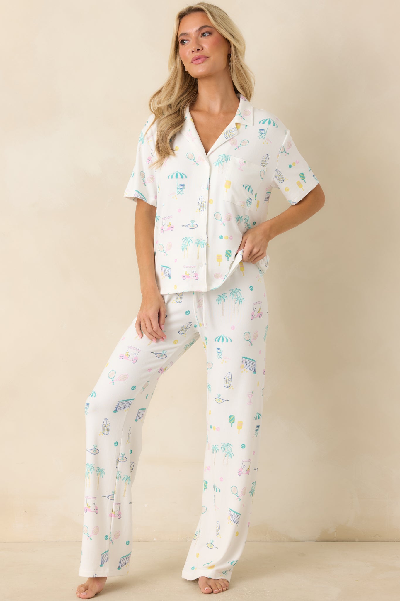Relaxed-fit pajama top showcasing a playful multi-sport print with a collared design, chest pocket, and easy drape.