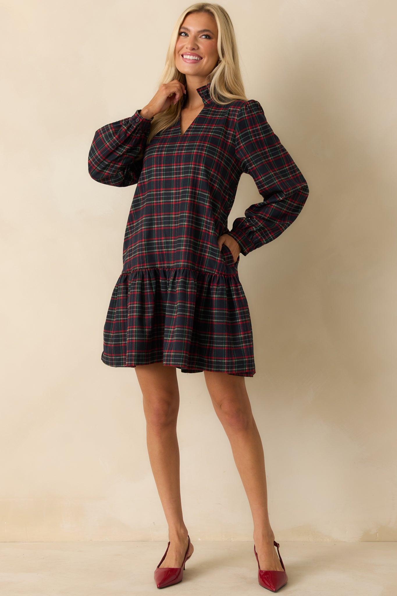 Relaxed-fit navy multi plaid mini dress with long sleeves, ruffled hem, and split neckline with standing collar.