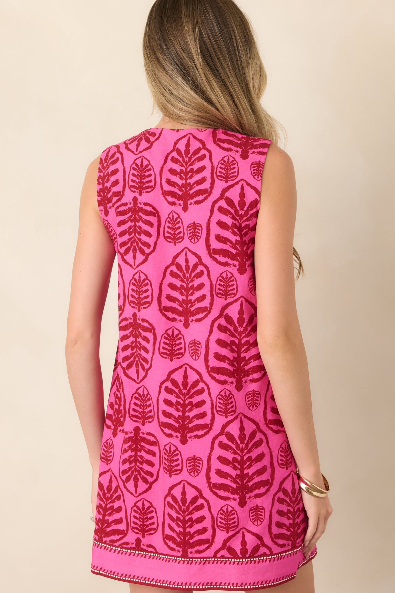 Rear view of the relaxed shift mini dress, highlighting its sleeveless silhouette, comfortable drape, and contrast stitching along the hem.