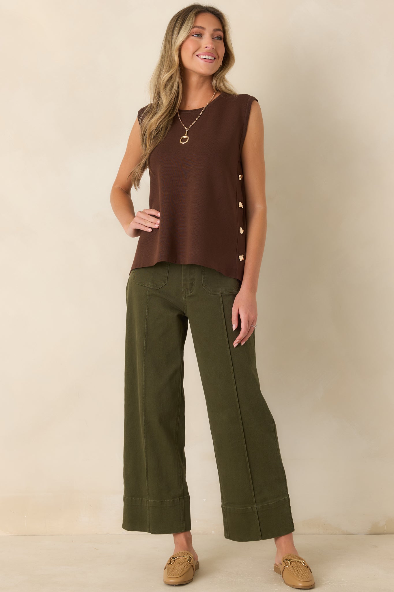 Relaxed sweater knit top designed with a classic crew neckline, flowing shape, and polished side button detailing.