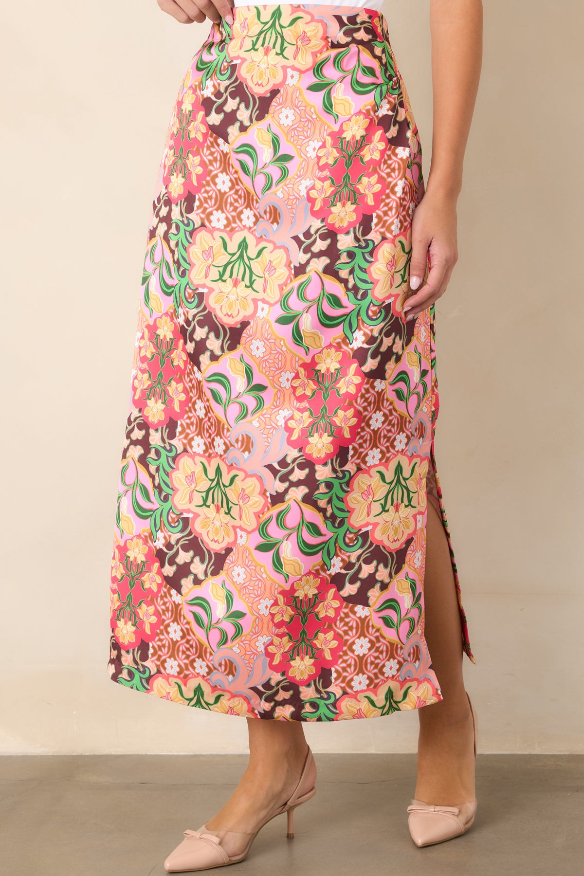 Close view of the retro floral medallion print in pink, coral, yellow, green, and chocolate brown.