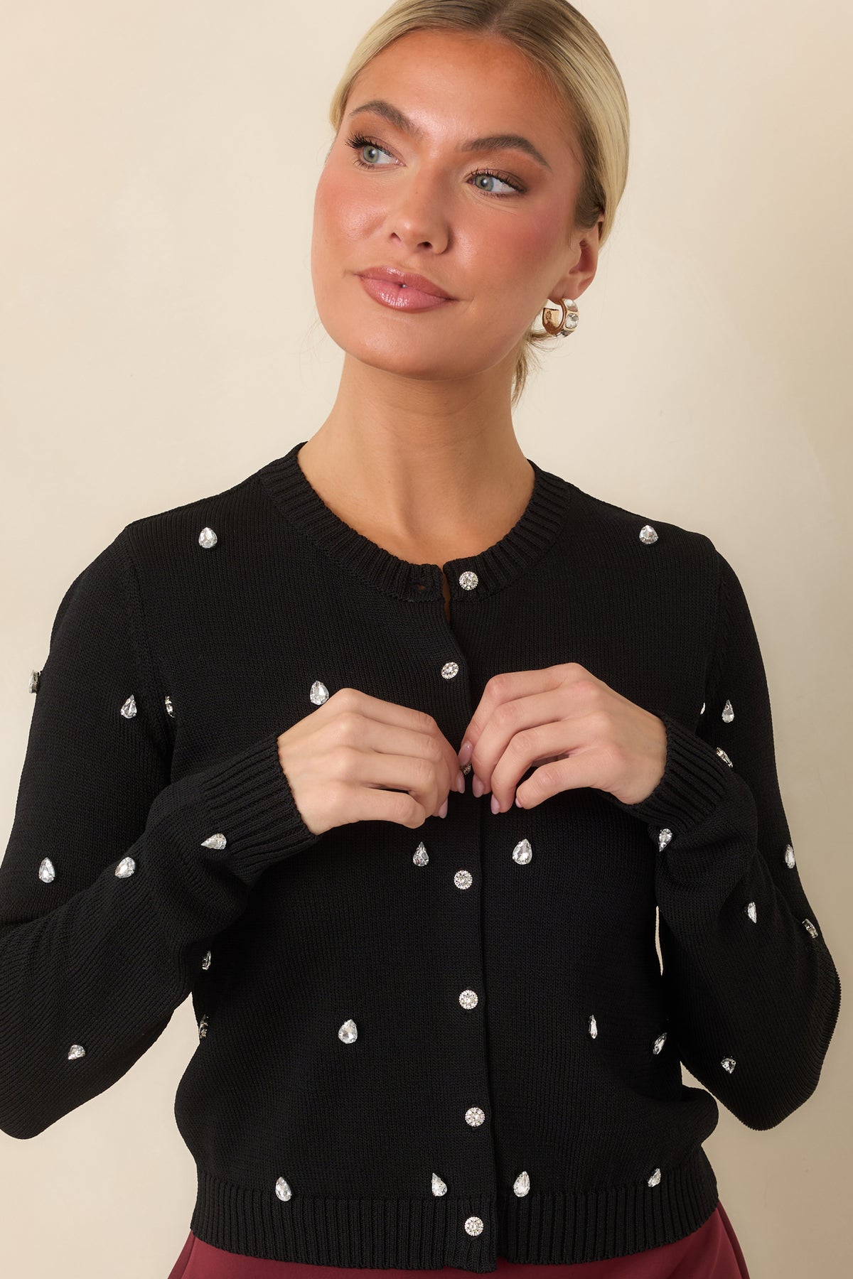 Jeweled cardigan featuring rhinestone-detailed sleeves and ribbed trim along the cuffs and hem.