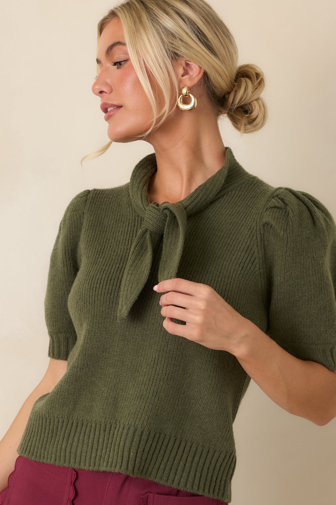 Ribbed blouse featuring a statement bow neckline and subtle sleeve volume for an elevated look.