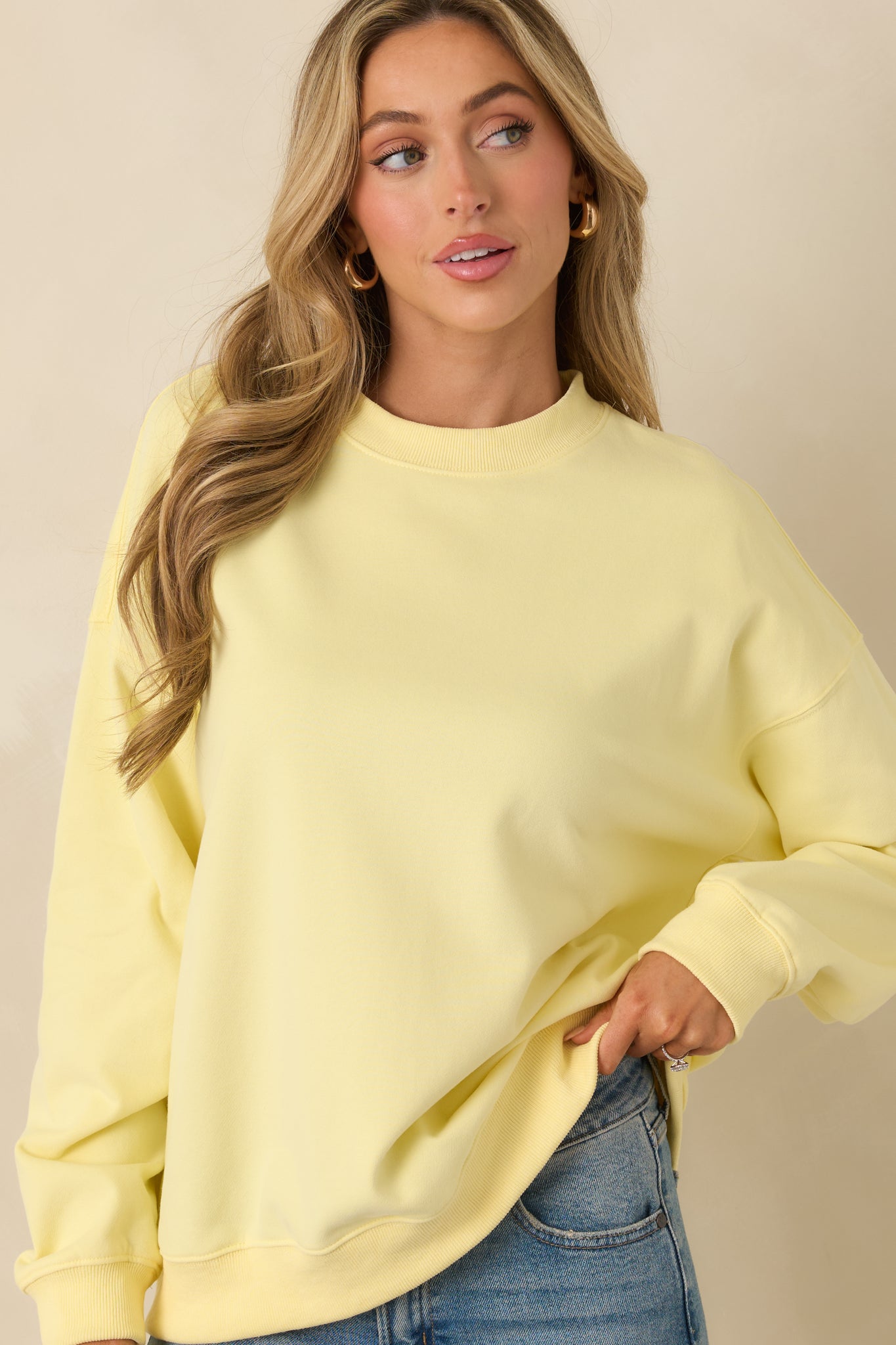 Ribbed cuff detail on a yellow sweatshirt with smooth stitching lines.