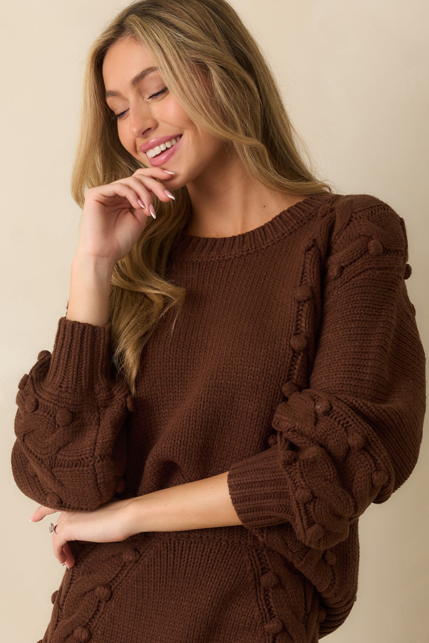 Ribbed hemline of the chunky knit brown sweater.