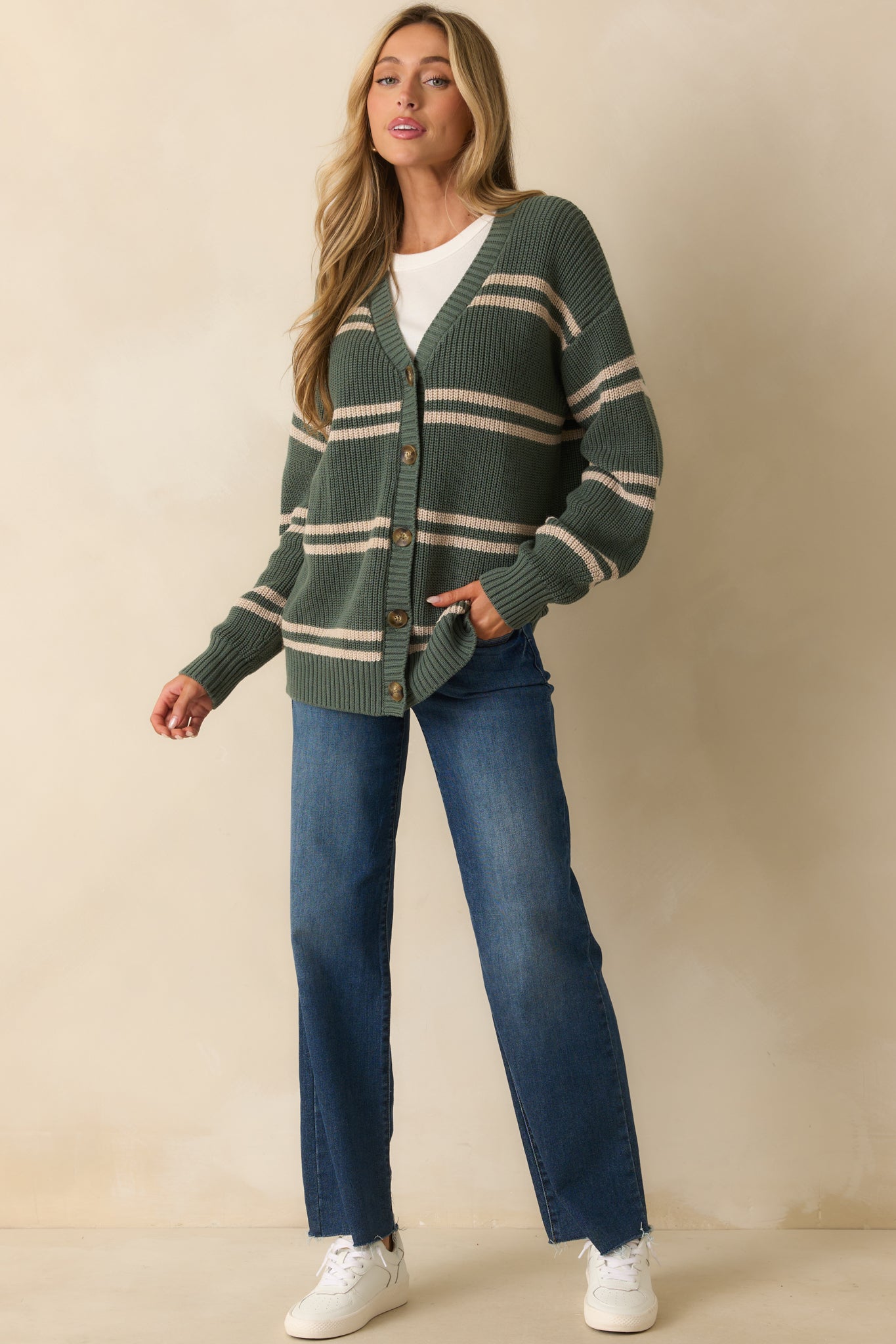 Ribbed knit cardigan in green with beige stripes, a V-neck, and a front button closure.