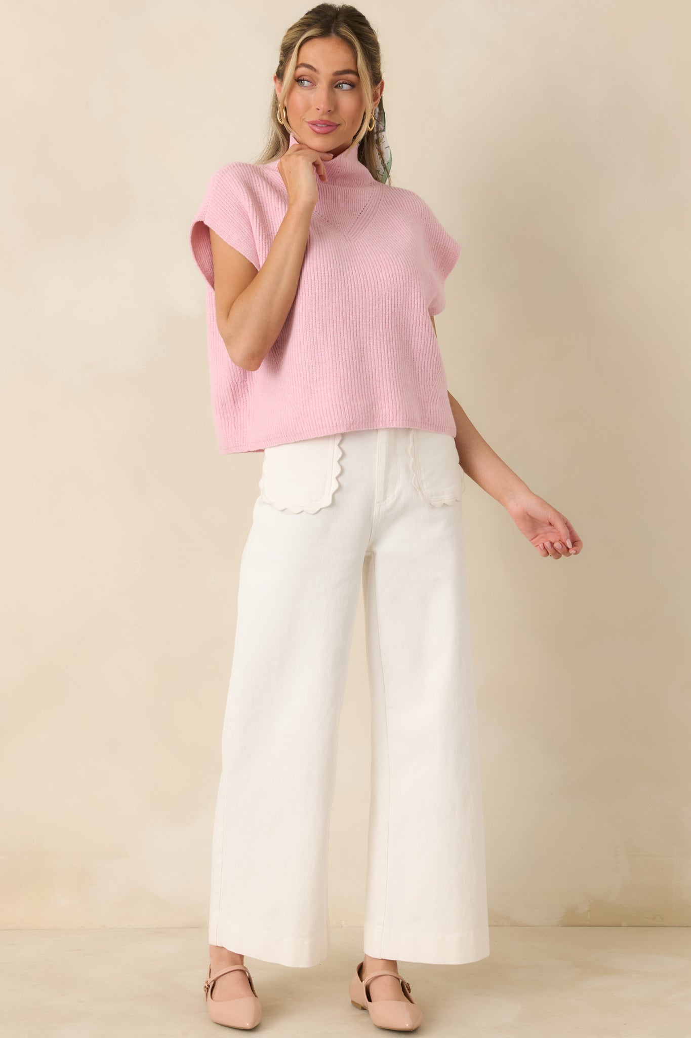 Ribbed knit sweater top in a soft light pink shade, designed with a mock collar and cap sleeve trim for gentle shape.