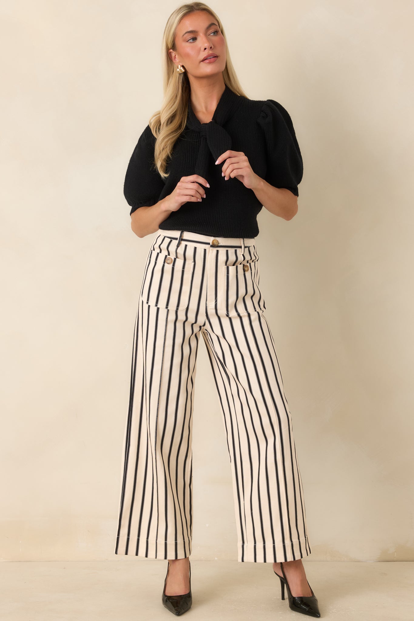 Ribbed knit sweater top featuring an oversized self-tie neckline, puff sleeves, and a fitted silhouette with a structured ribbed hem.