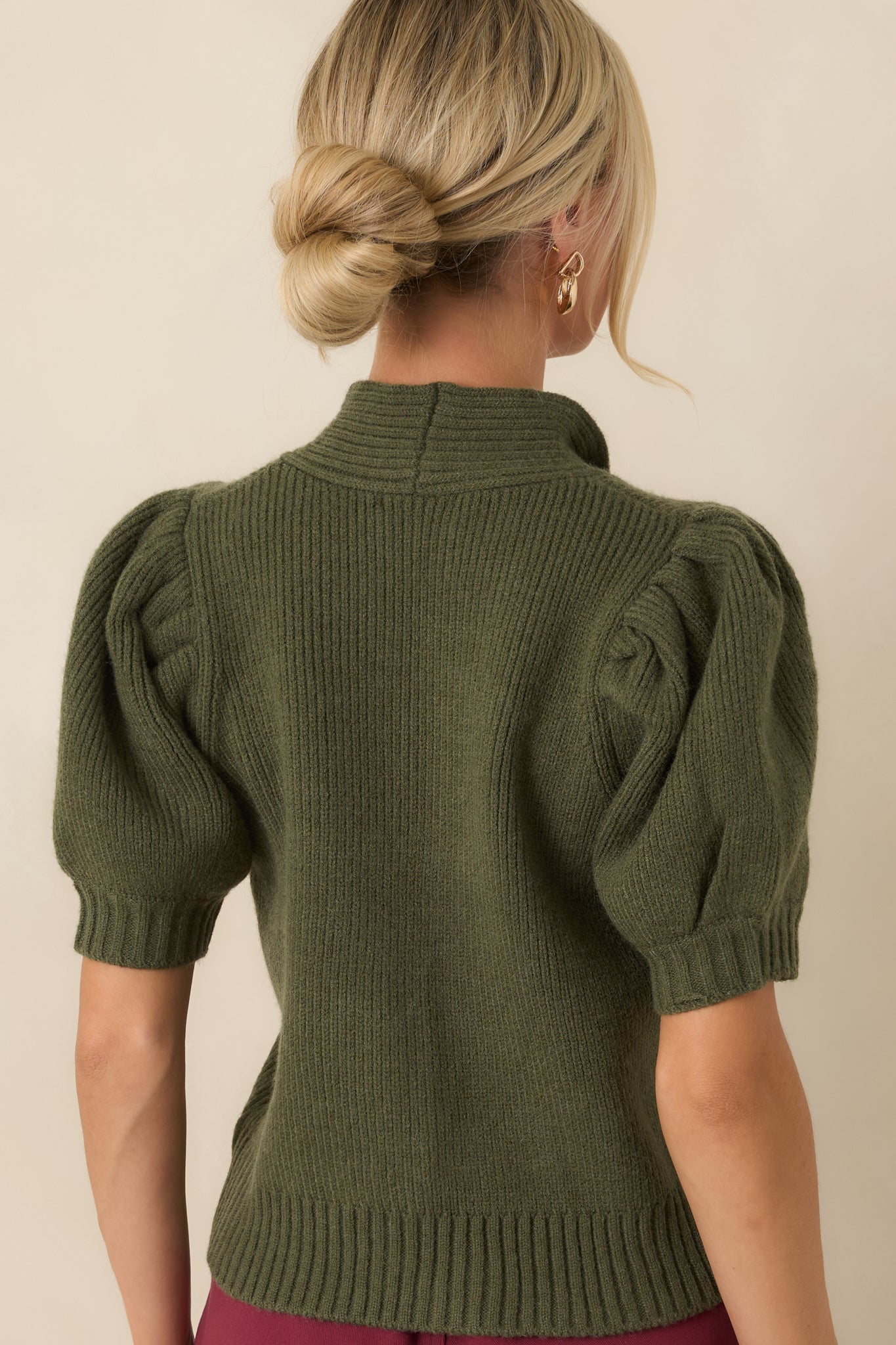 Back view of the ribbed knit top featuring a fitted silhouette, long sleeves, and a clean ribbed finish.