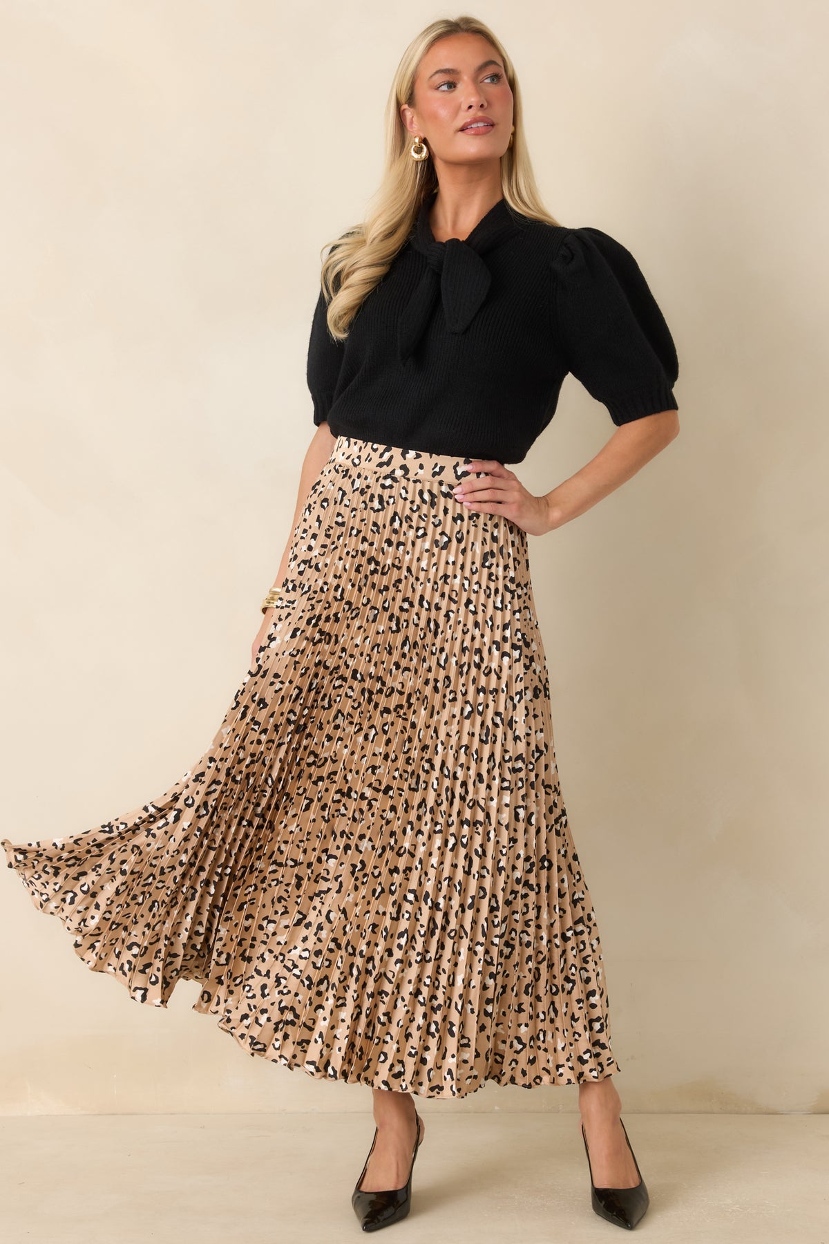Ribbed sweater top featuring a feminine self-tie neckline, fitted silhouette, and puff sleeves that add a sophisticated touch to the timeless design.