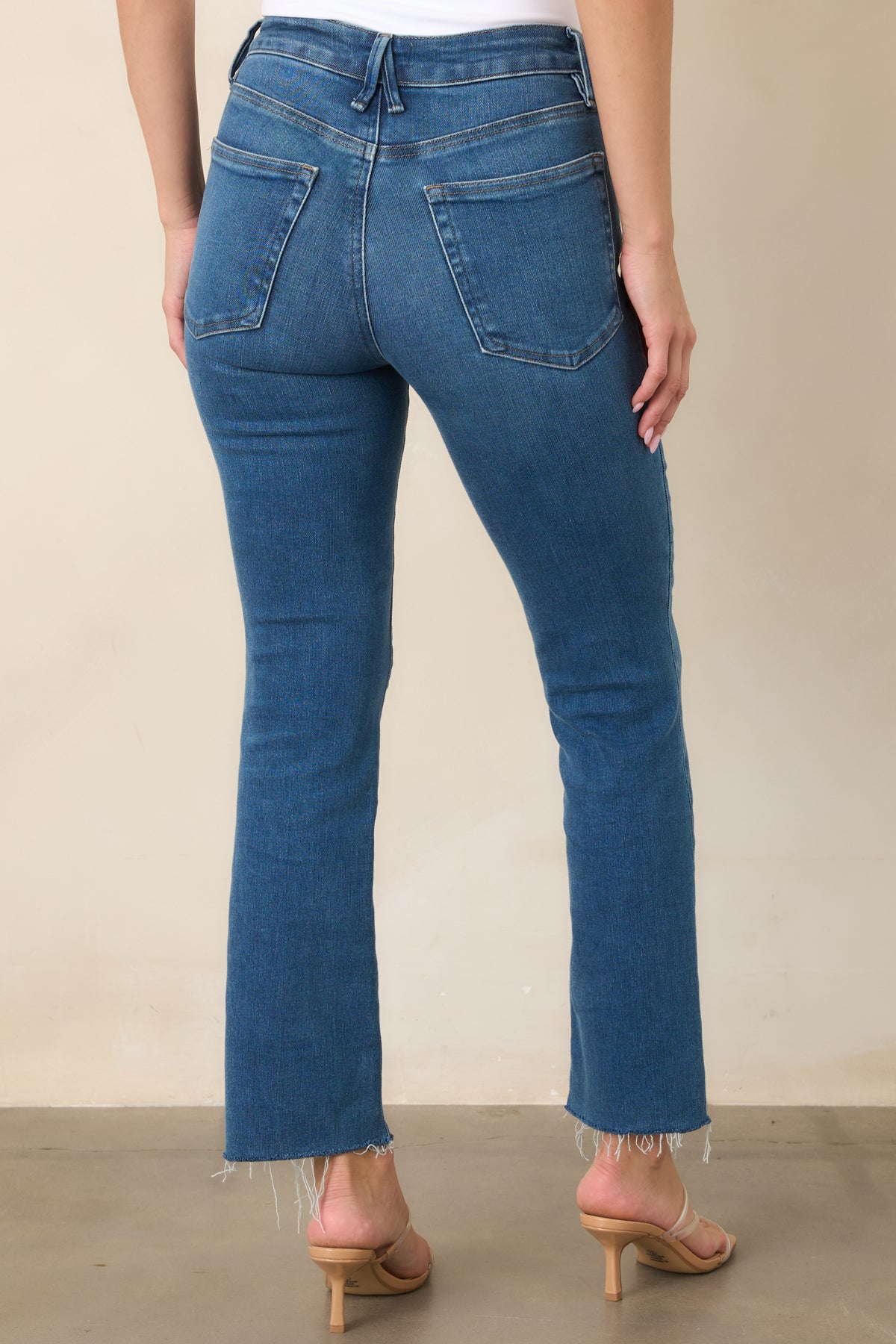 Rear of the rich blue straight-leg pants featuring classic back pockets and raw ankle-length hems.