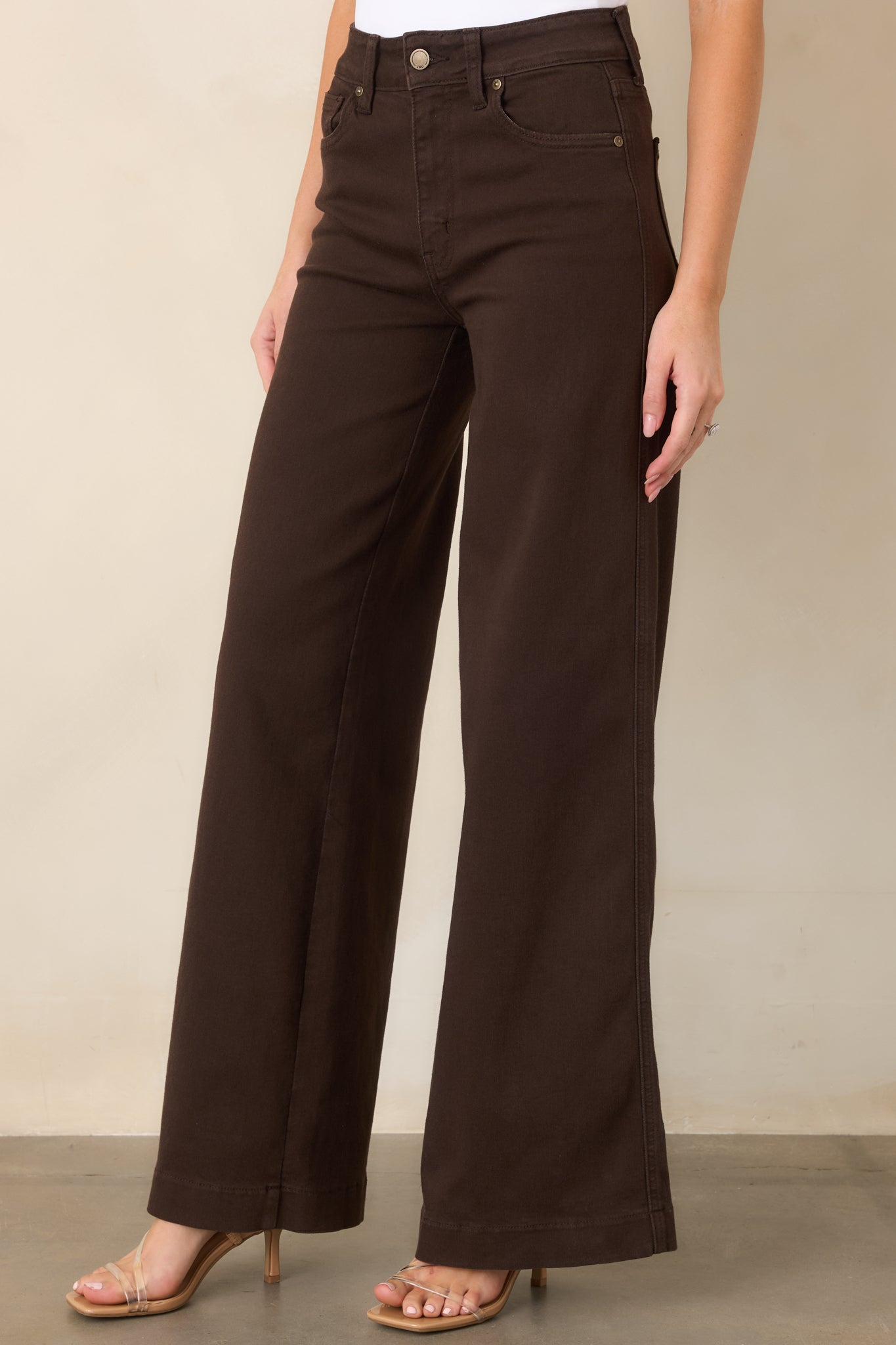 Rich brown jeans showcasing the classic five-pocket detailing, sturdy belt loops, and smooth denim texture.