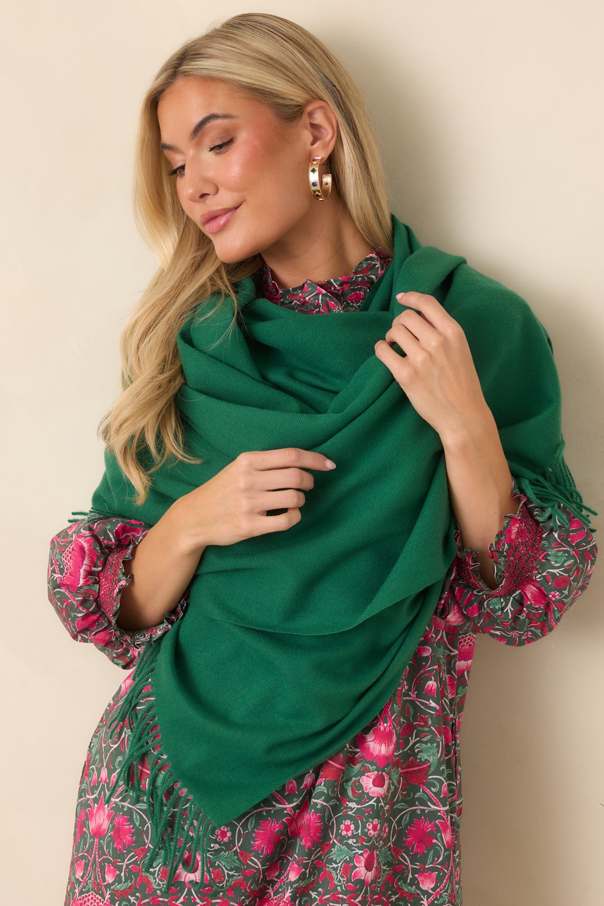Rich green scarf draped in a generous silhouette with delicate fringe trim along the edges.