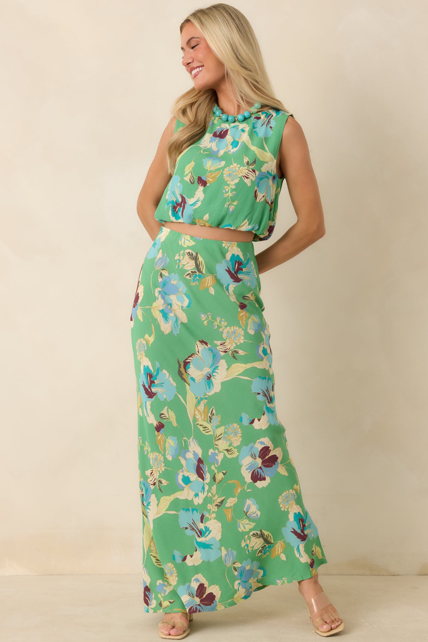 Romantic green floral top with a lightweight fabric, sleeveless design, and softly shaped bubble hem.