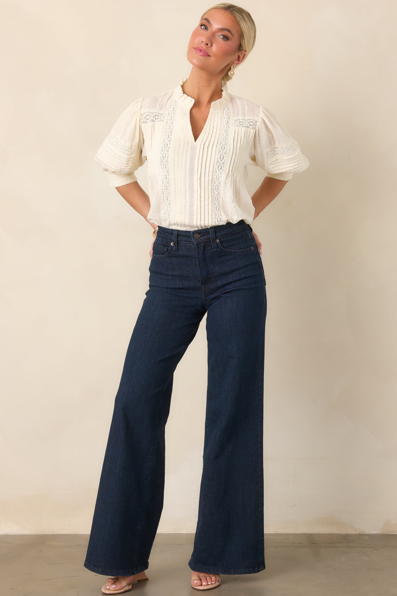 Romantic lace-accented blouse showcasing dimensional pleating, a gently ruffled neckline, and airy balloon sleeves with intricate lace panels.