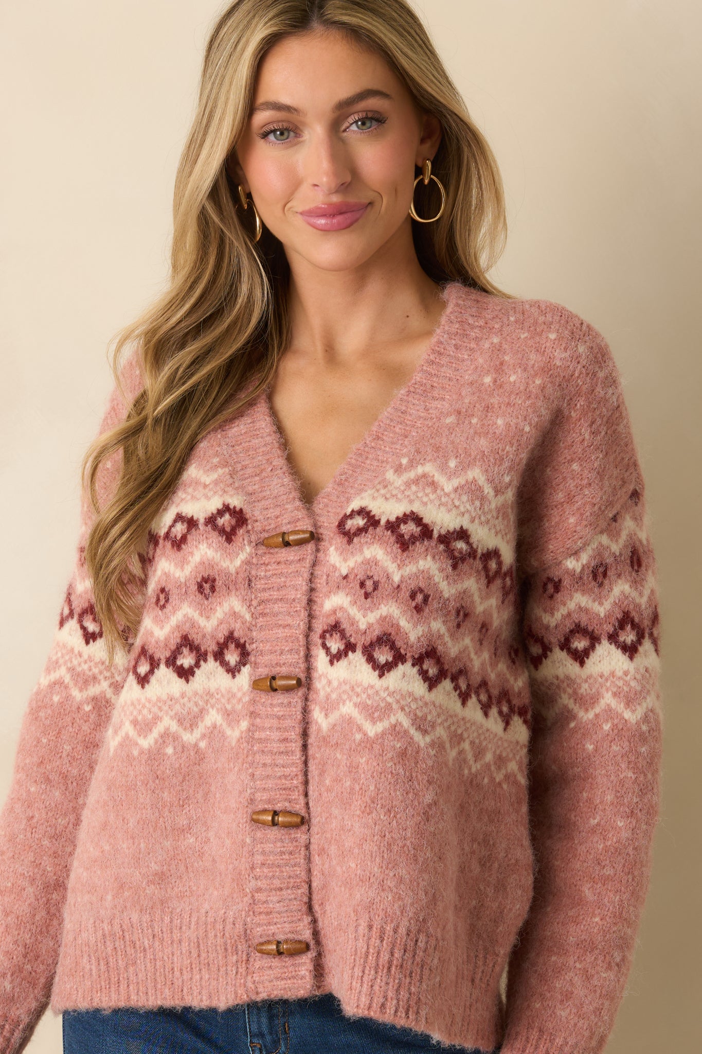 Textured knit and ribbing along the hem and cuffs of the rose pink cardigan.