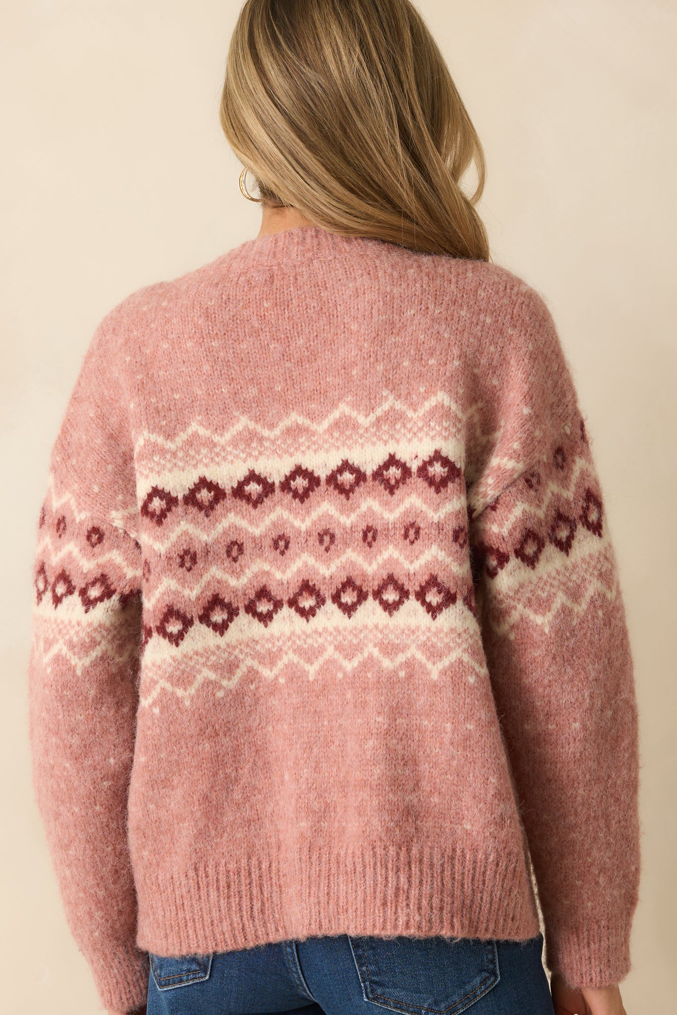 Rear view of the rose pink cardigan showing the ribbed hem and clean knit fabric.