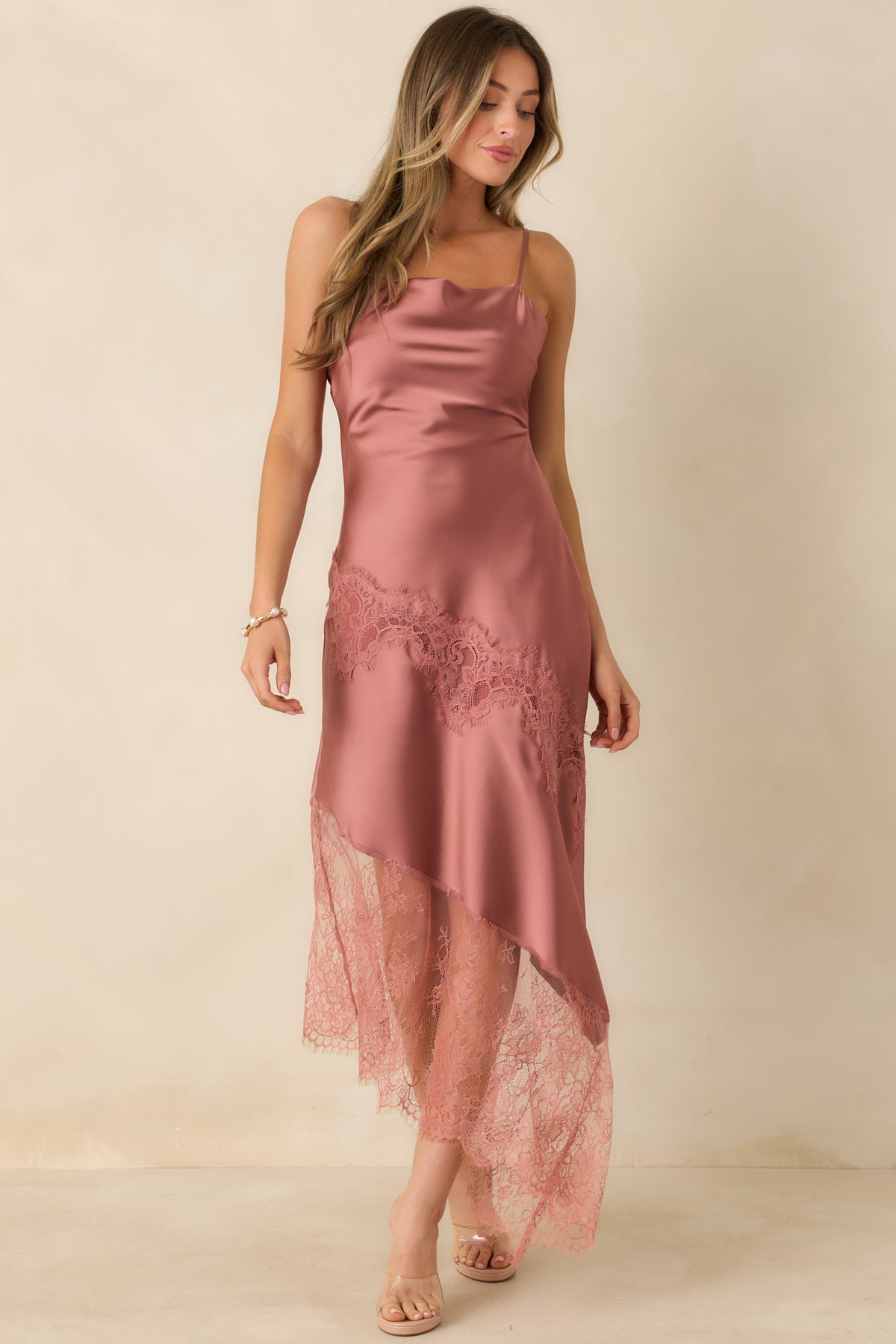 Rose pink satin dress with a draped cowl neckline, delicate spaghetti straps, and diagonal floral lace detailing.