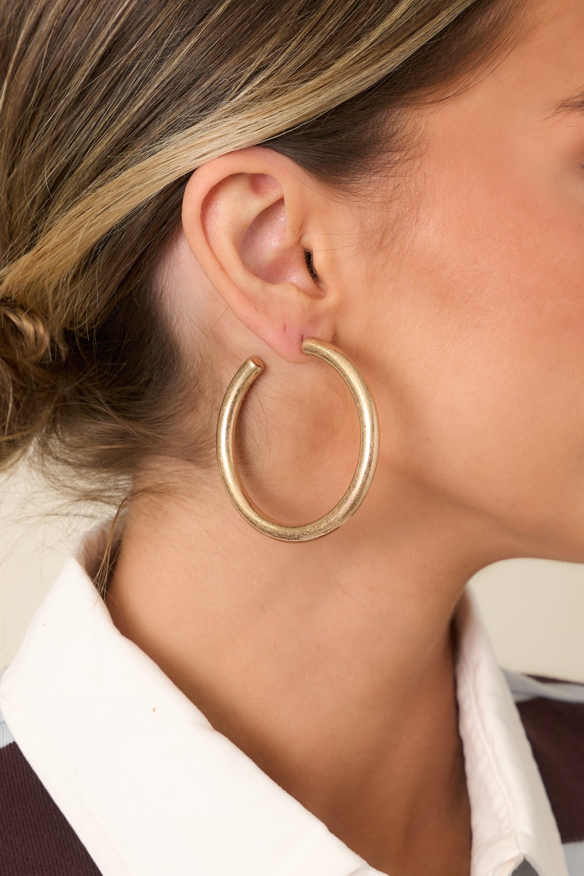Round hoop earrings feature a bold open silhouette with smooth rounded edges and subtle surface texture.