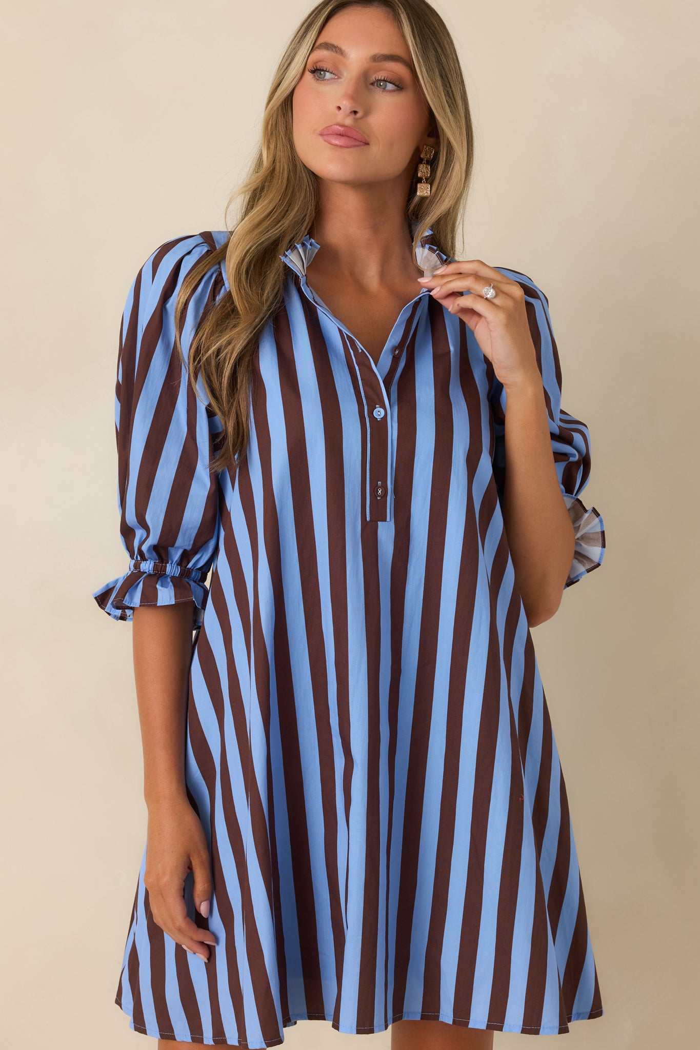 Detailed view of the ruffled mock collar and partial button-front placket showcasing the feminine cotton design.