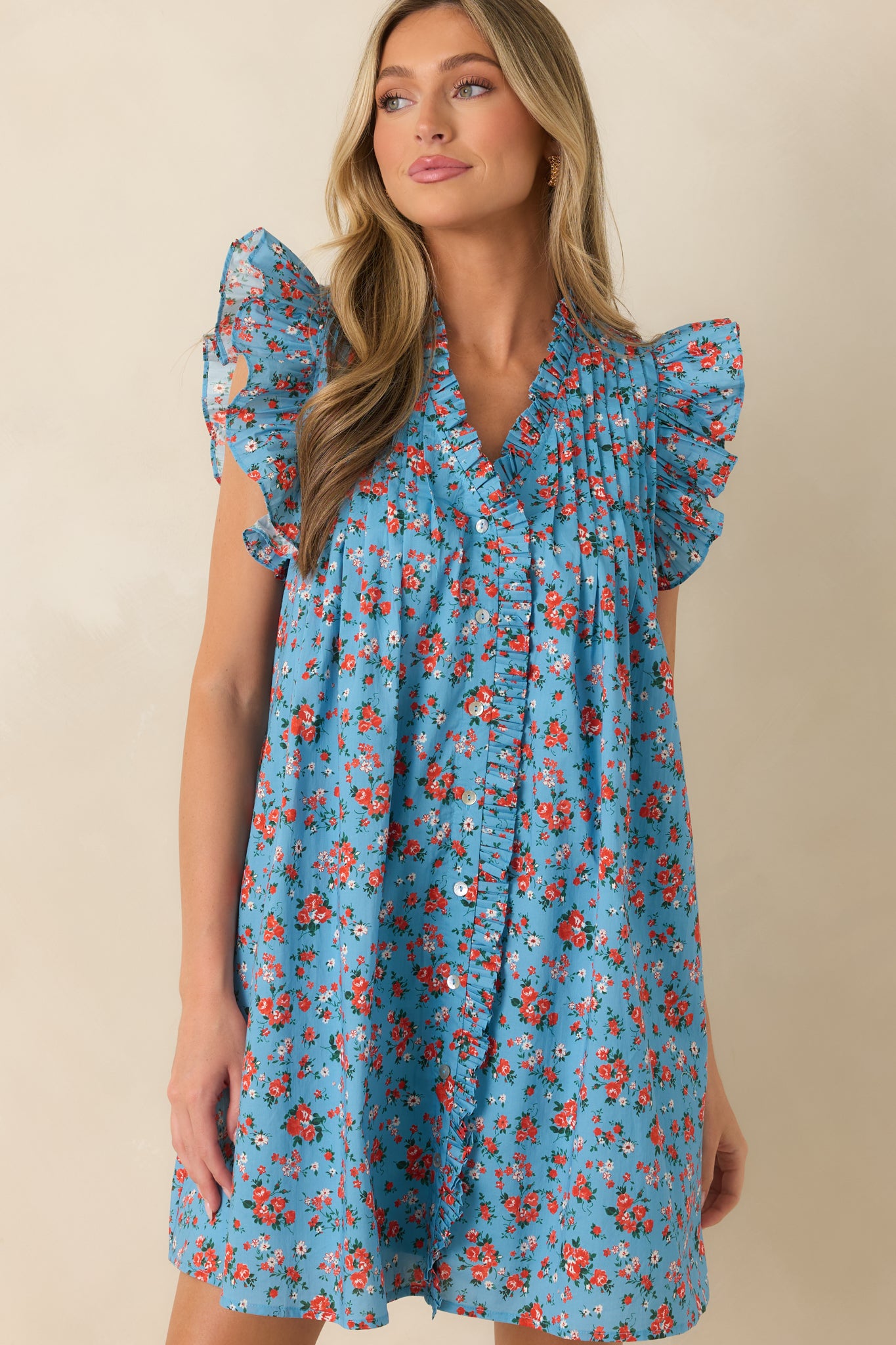 Ruffled V-neckline and delicate pleated yoke detailing add feminine texture to this light blue floral mini dress.