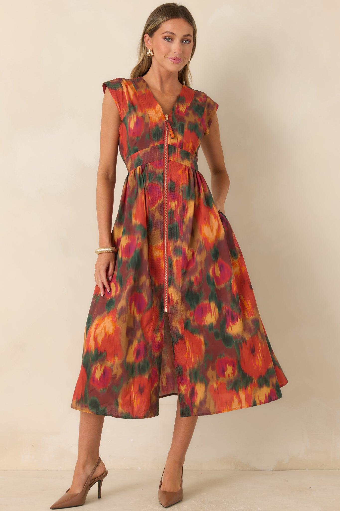 100% cotton midi dress showcasing a rich rust base with orange, green, gold, and berry florals, fitted bodice, and flowing gathered skirt.