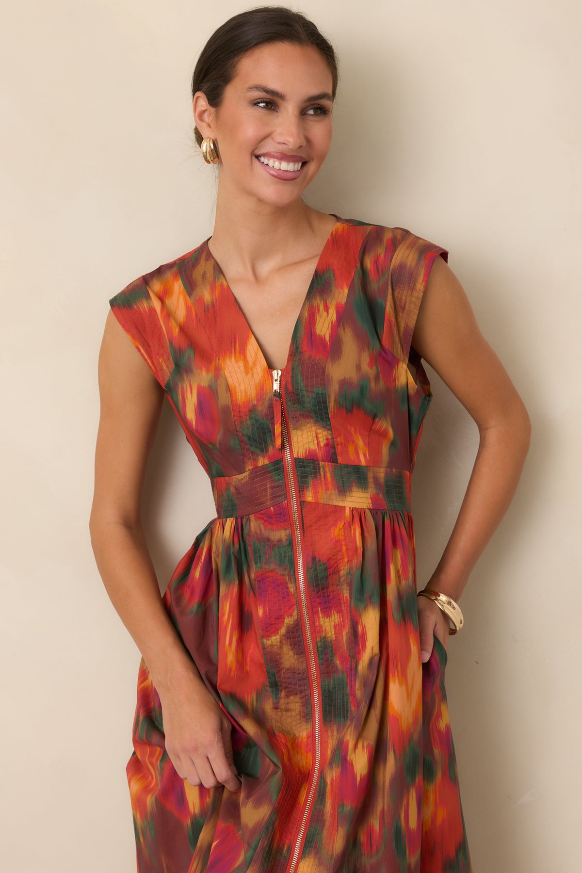 Rust floral dress highlighting the V-neckline, structured cap sleeves, fitted bodice, and gold-tone zipper detail.