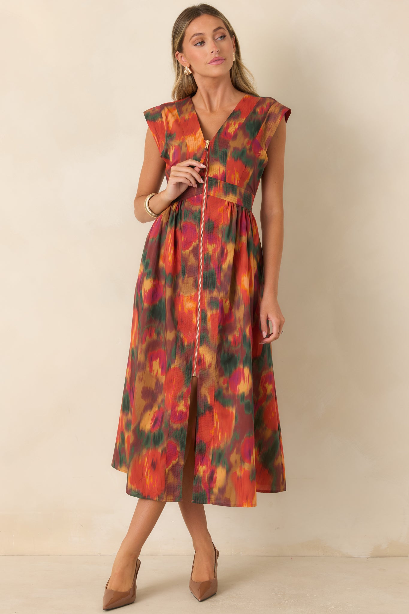 Floral midi dress designed with a V-neckline, structured cap sleeves, cinched waist, and voluminous skirt accented by a front gold-tone zipper.