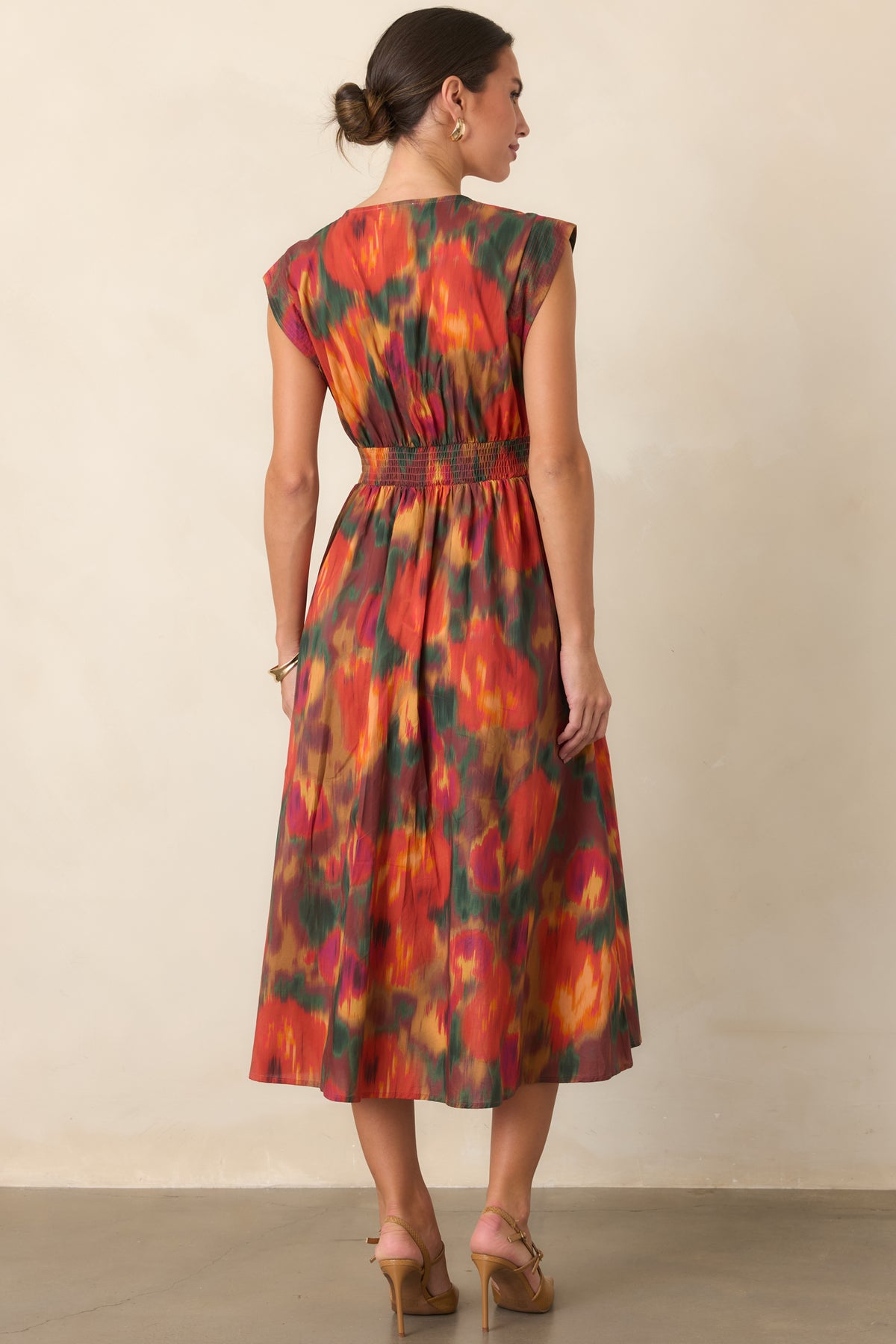 Rear of the rust floral midi dress featuring the smocked back waist, structured cap sleeves, and gathered full skirt.