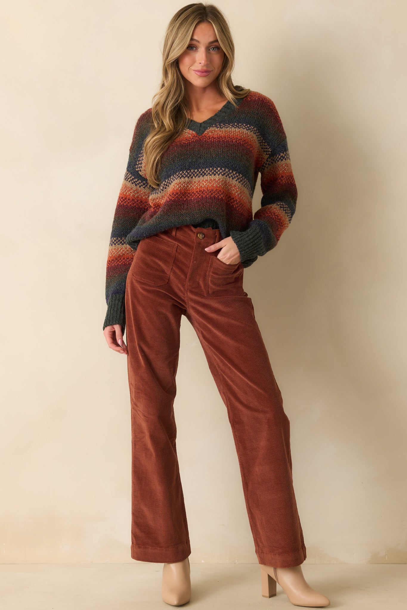 Cozy rust knit top with vibrant multicolor stripes, relaxed fit silhouette, ribbed trim, front facing.