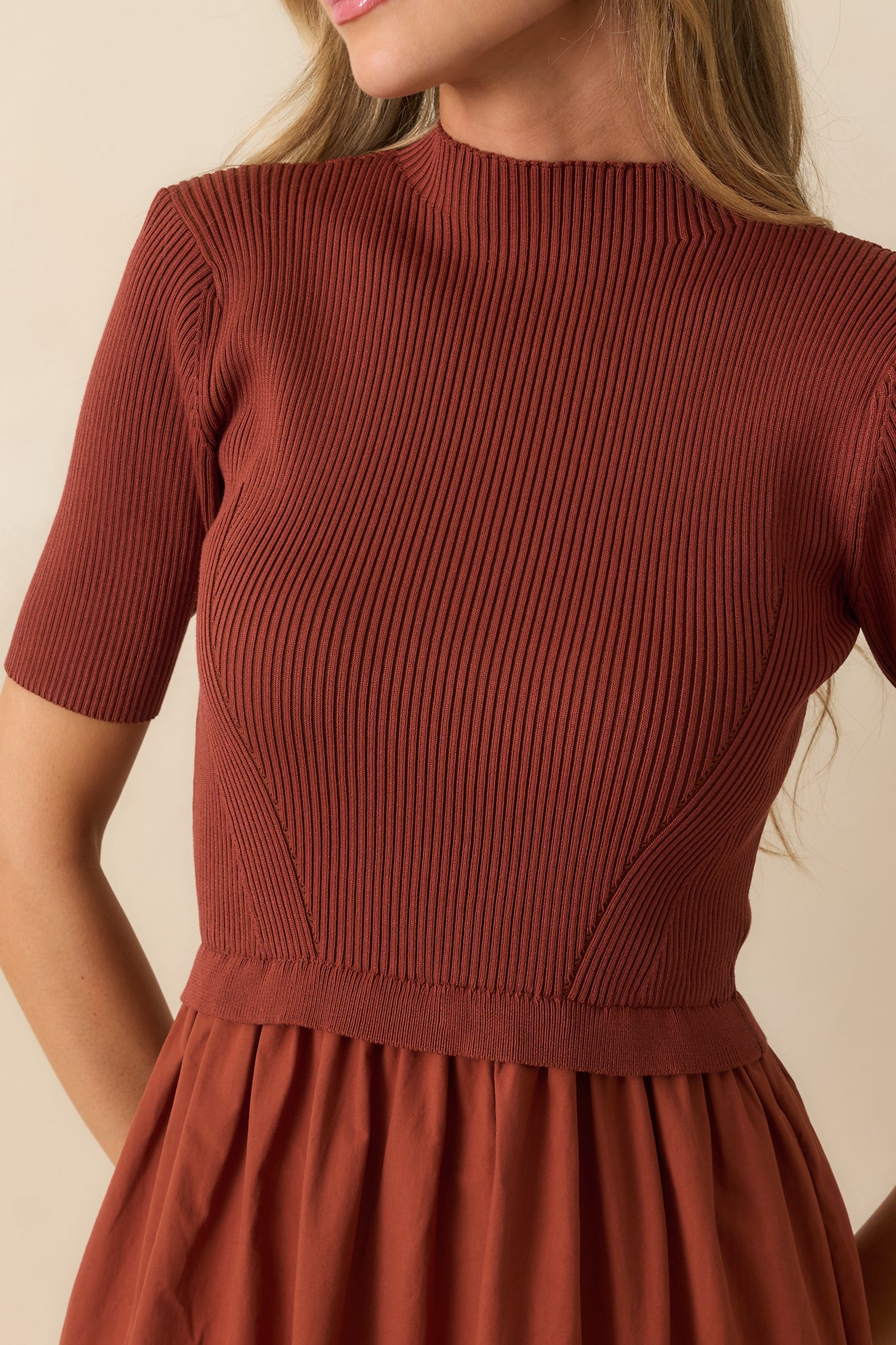 Close-up of the rust red maxi dress highlighting the ribbed knit bodice, crew neckline, ruffle-trimmed waist, and short sleeves.