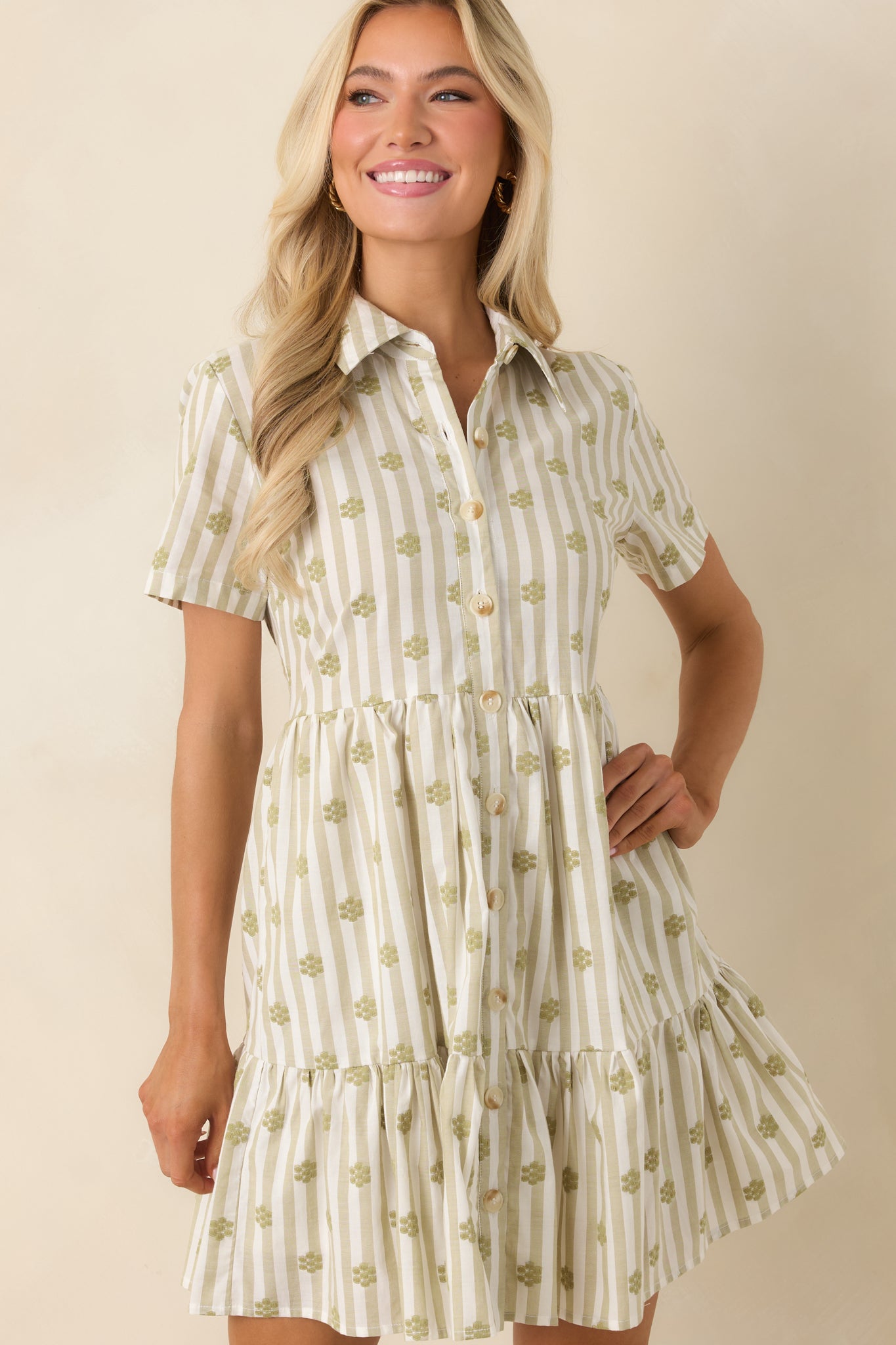 Sage green floral embroidered mini dress showcasing the textured fabric, tiered skirt layers, and functional side pocket details.