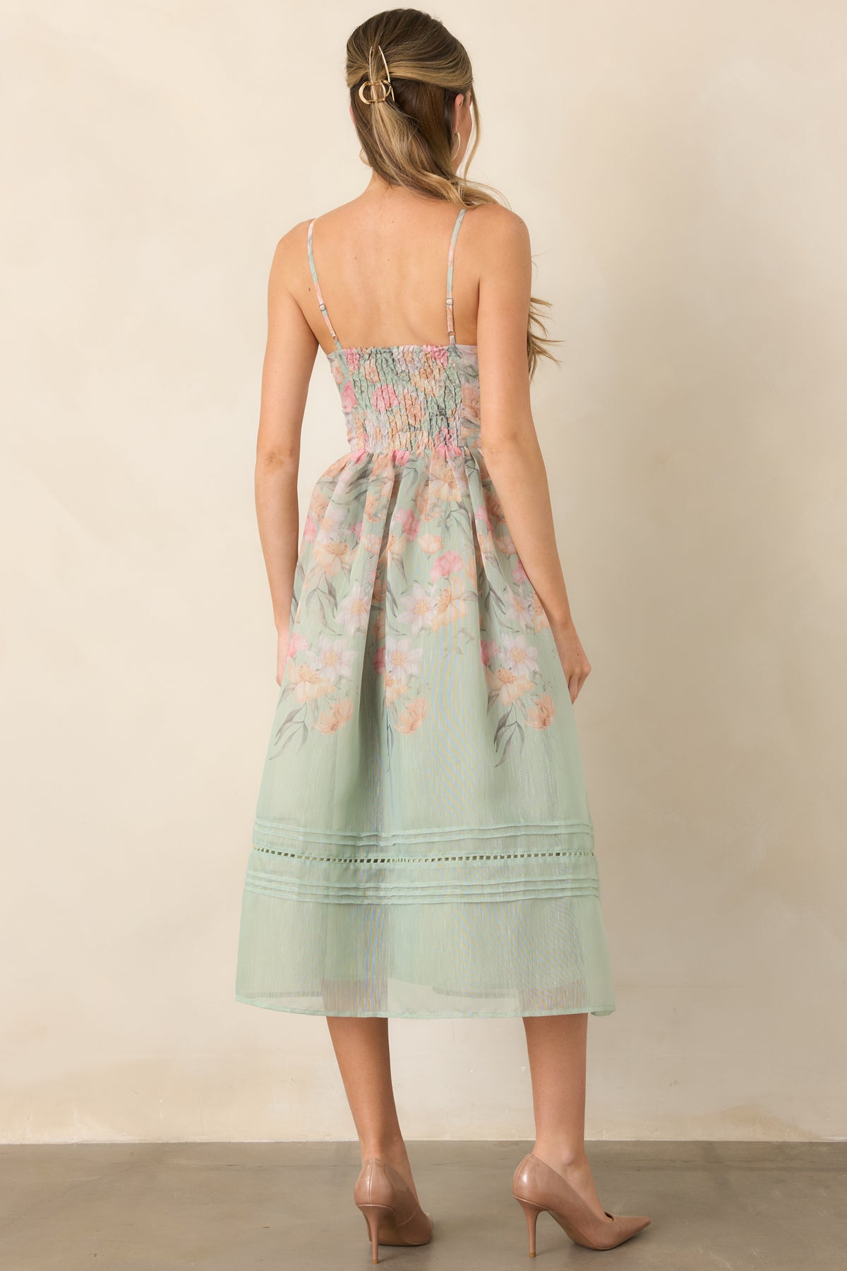 Rear of sage green floral dress showing smocked back and defined waist.