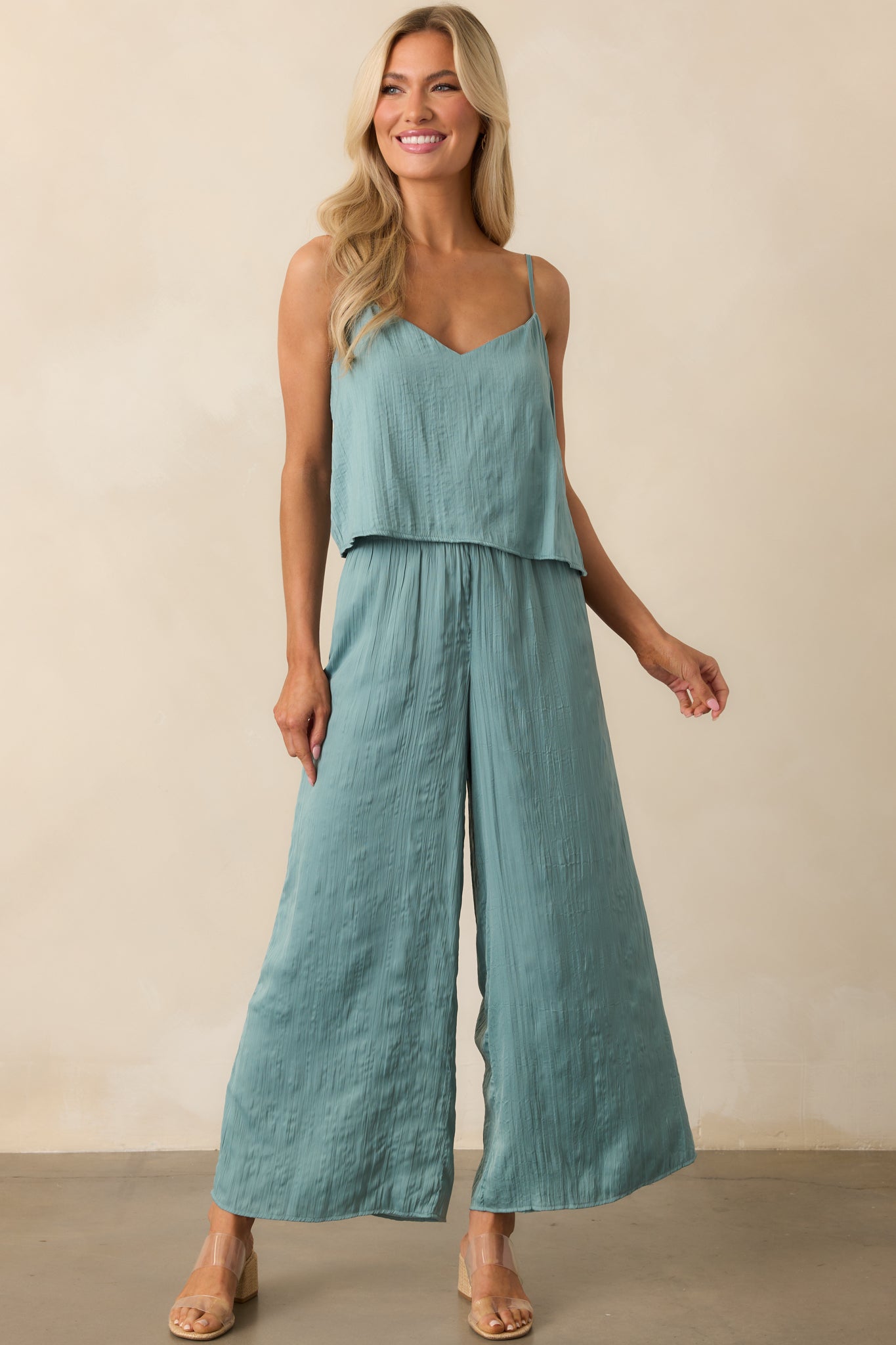 Full view of the sage green pants showing the high-rise waist and wide leg silhouette in crinkle satin fabric.