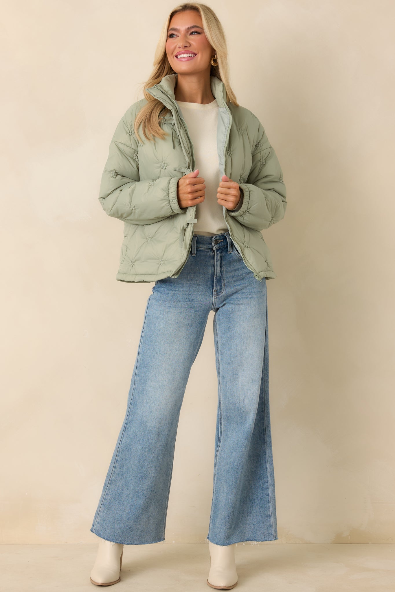 Relaxed-fit sage green quilted jacket with straight hem, stitched floral pattern, and warm insulated construction.