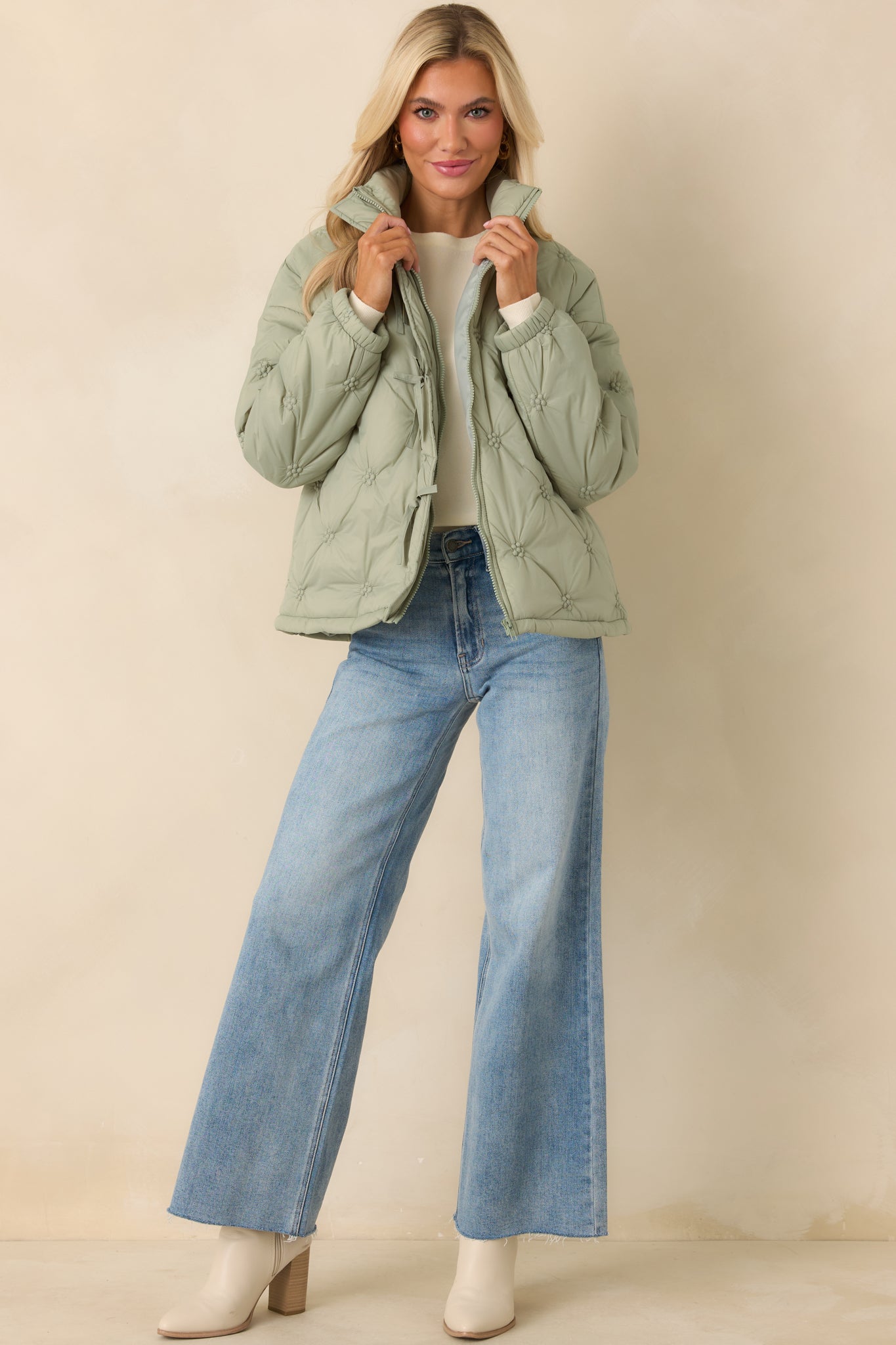 Sage green quilted puffer jacket with allover floral-inspired stitching, stand collar, and full front zipper closure.