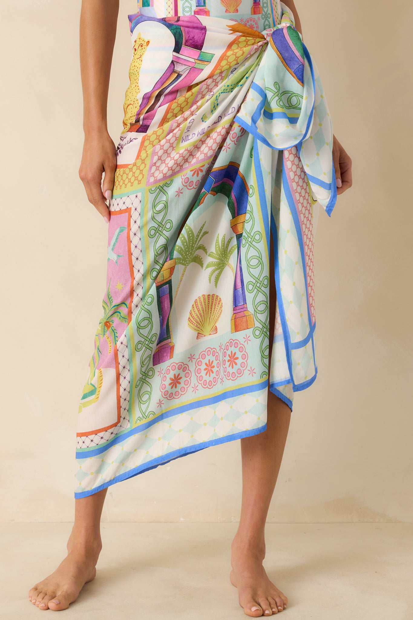 Front of sarong highlighting adjustable waist tie and vibrant tropical tile print.